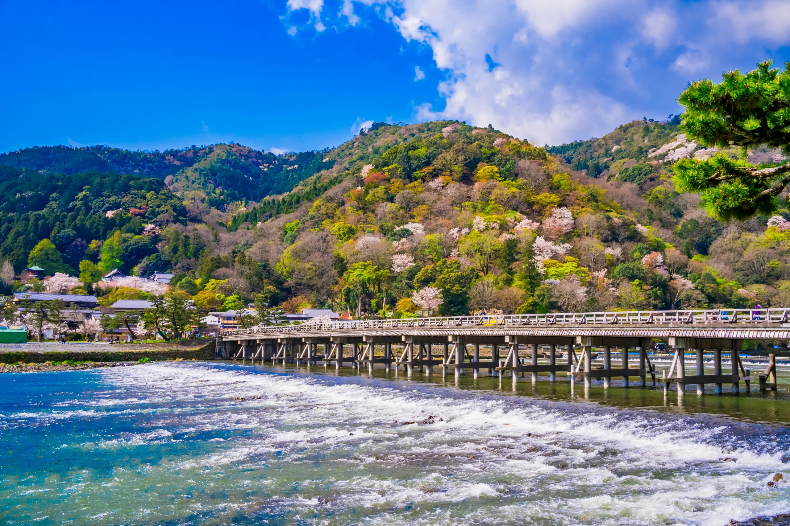 Scenic bridge in Arashiyama with a mountain backdrop.