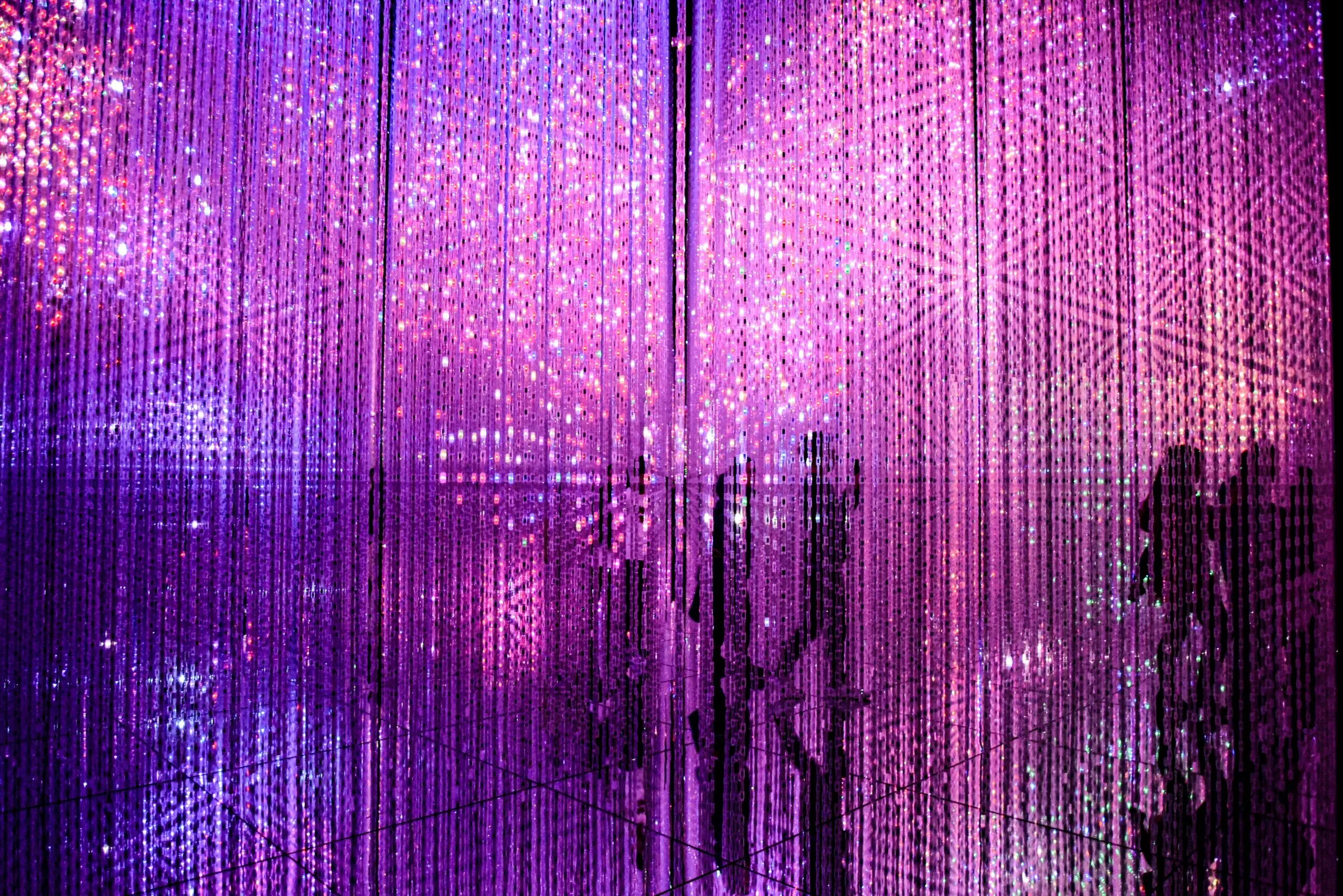  Immersive digital art with cascading purple and pink LED lights at teamLab Borderless.