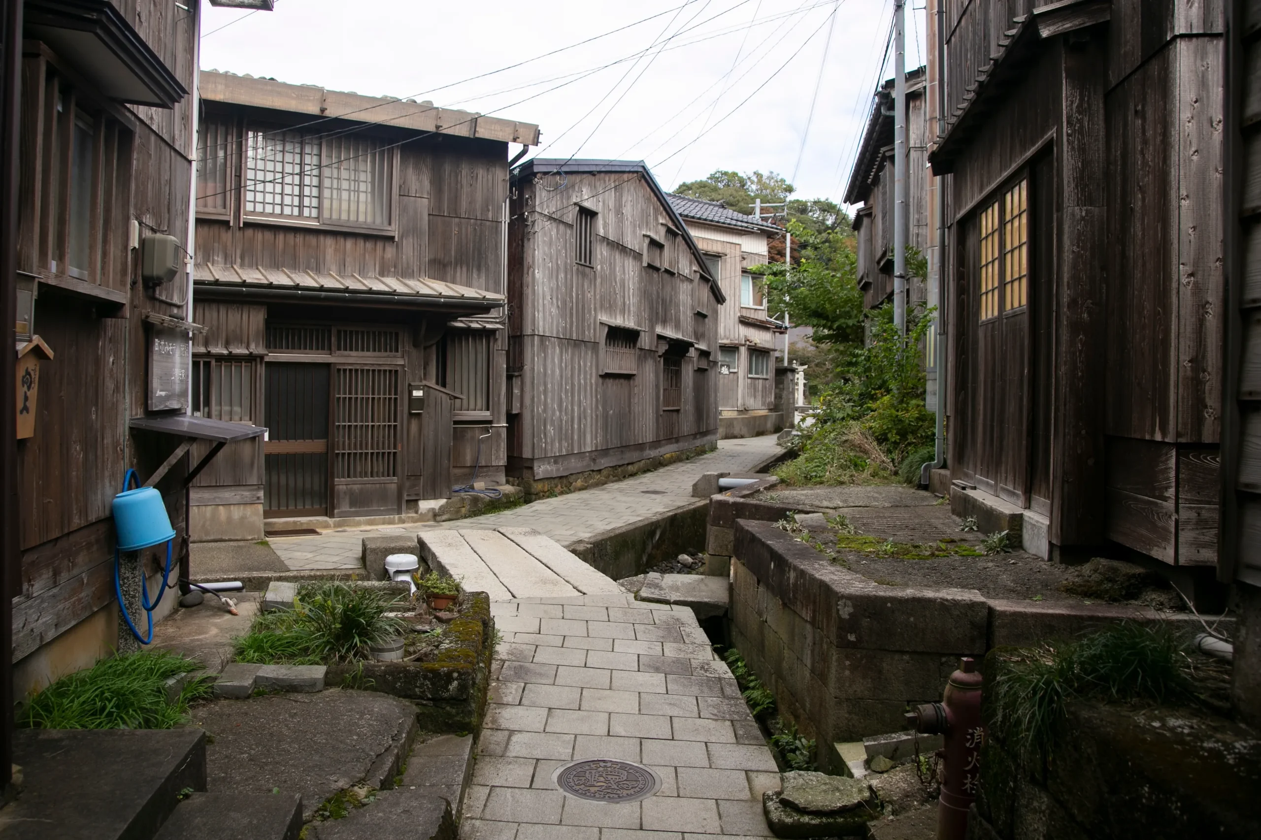 A historic fishing village with narrow stone-paved paths and traditional wooden houses, evoking a rustic charm and a sense of nostalgia.