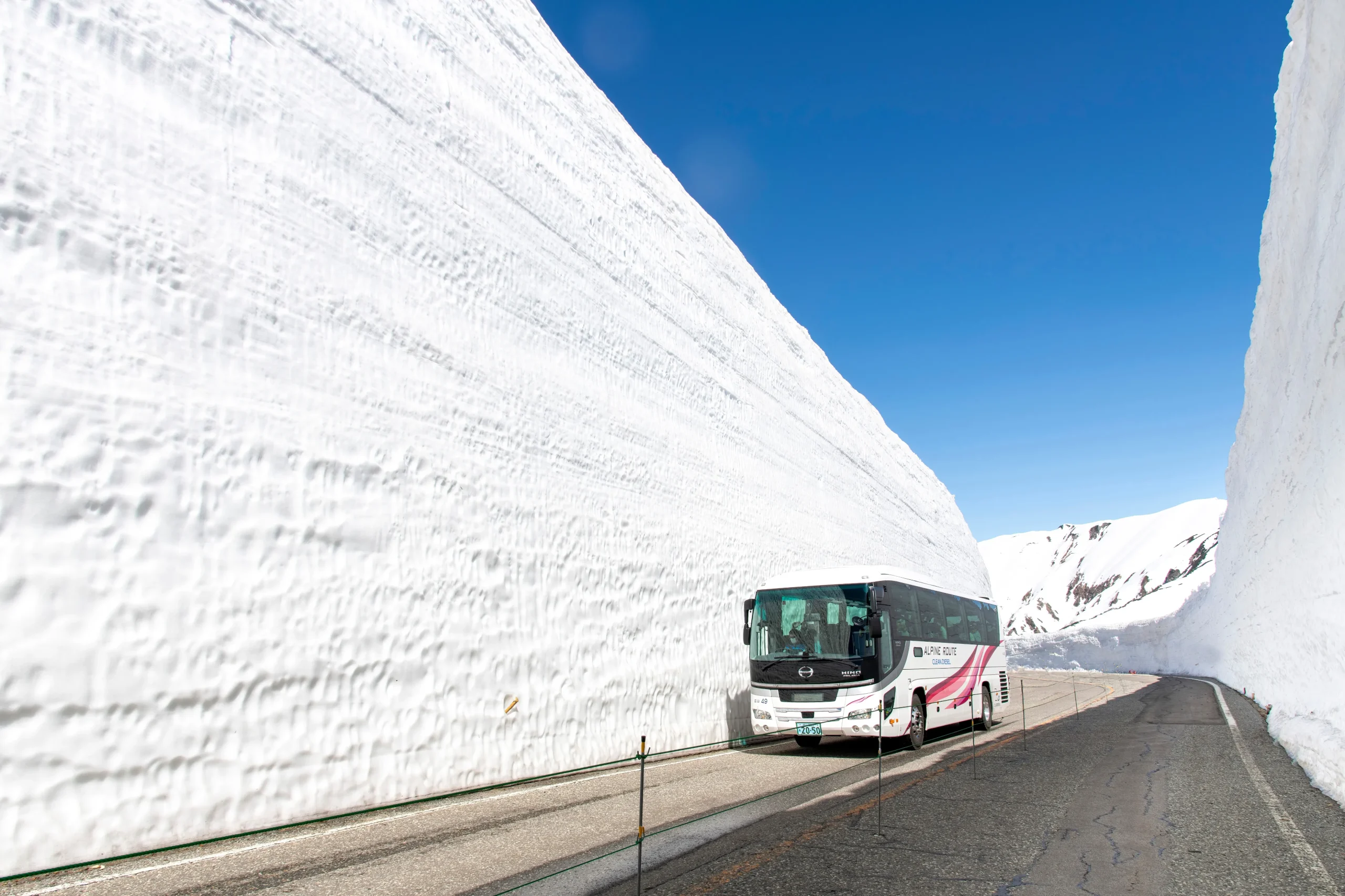 Tour bus driving through the Snow Corridor on the Tateyama Kurobe Alpine Route