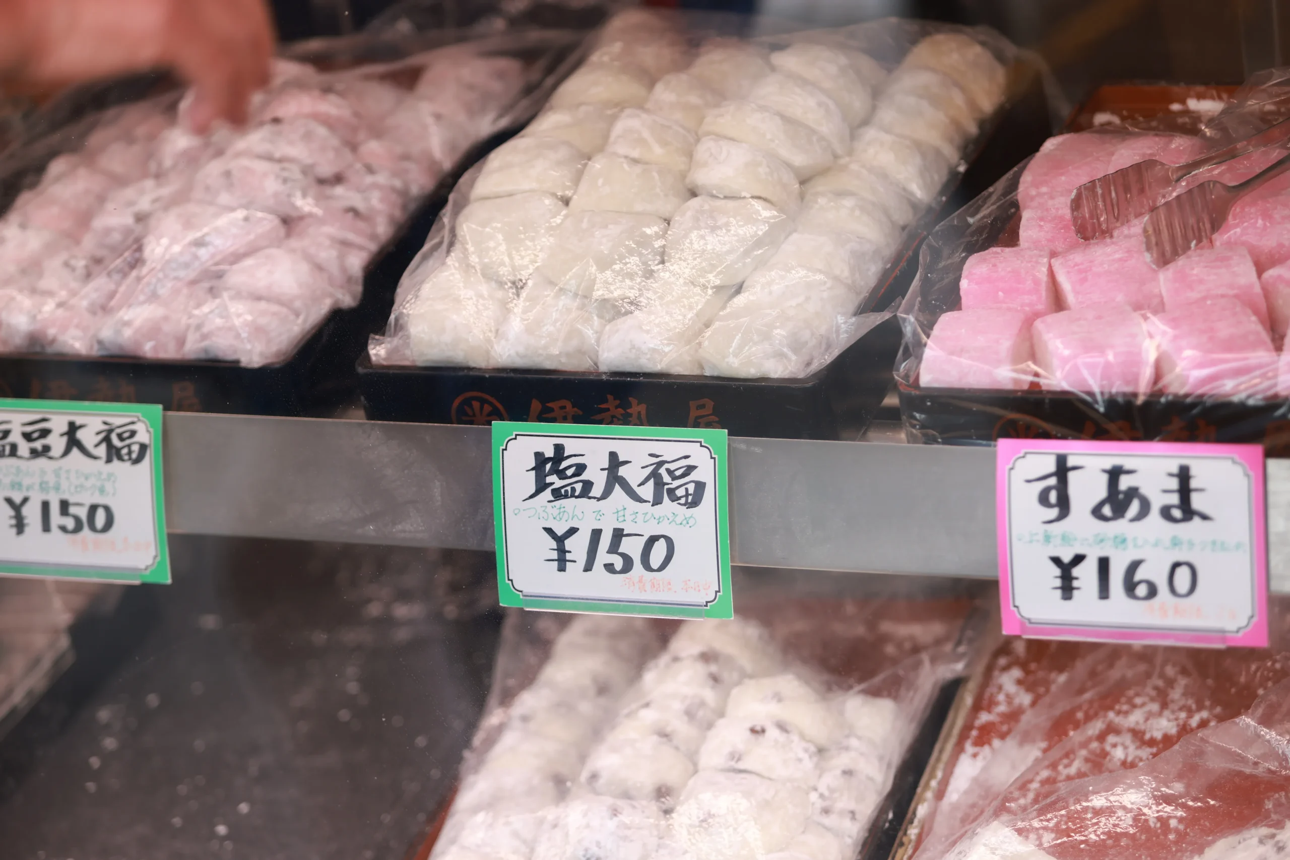 A display of traditional Japanese sweets, wagashi in a shop, featuring daifuku.