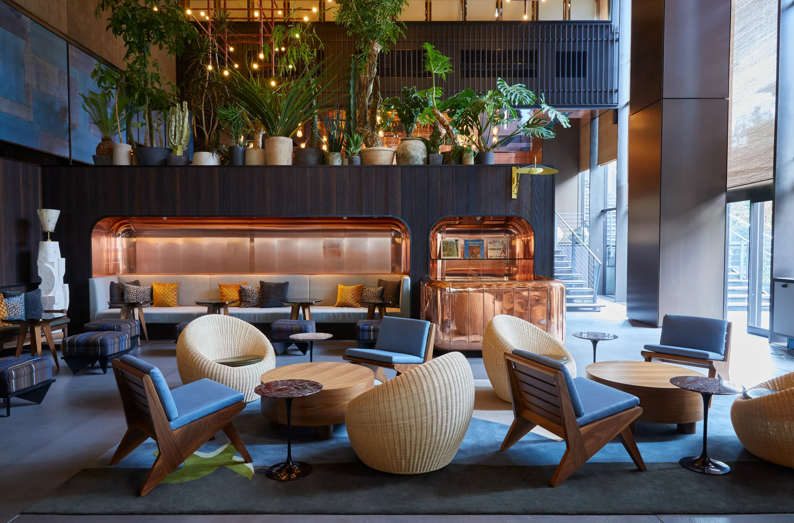 Trendy lobby at Ace Hotel Kyoto with modern furniture, lush greenery, and eclectic design.