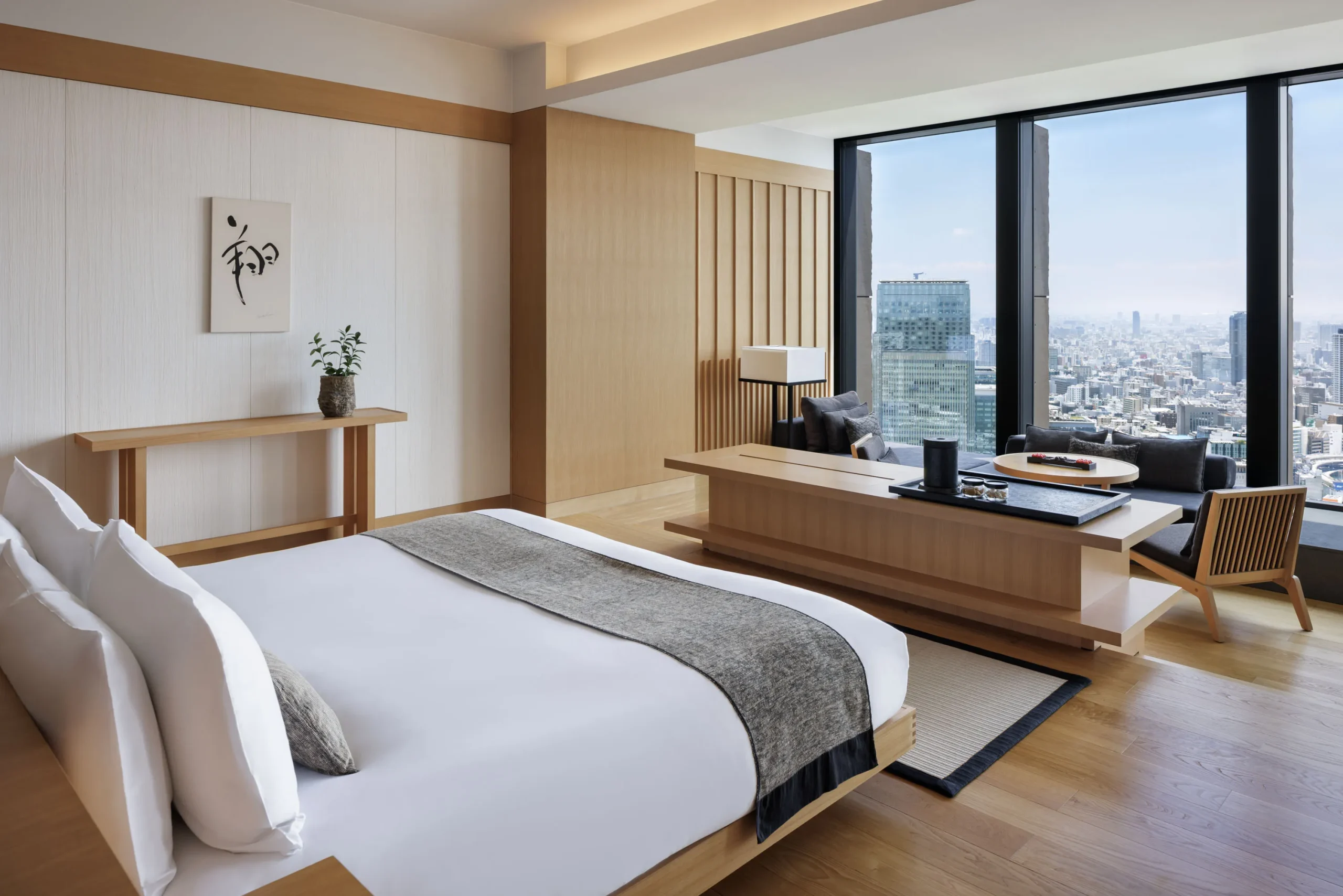 bedroom at Aman Tokyo blending Japanese aesthetics with luxury, featuring large windows overlooking the cityscape.