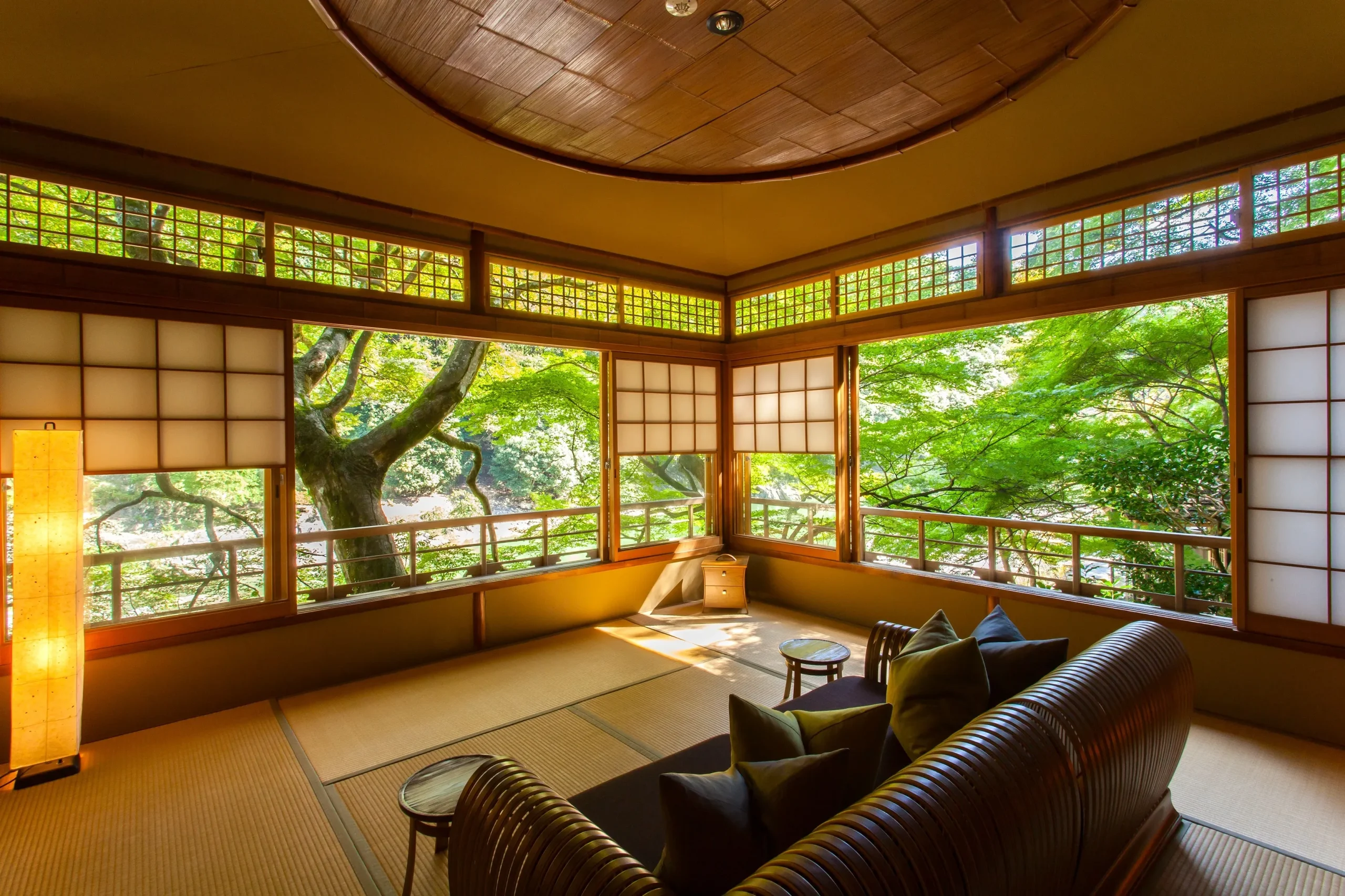 A serene tatami room at HOSHINOYA Kyoto with wide windows overlooking lush greenery.