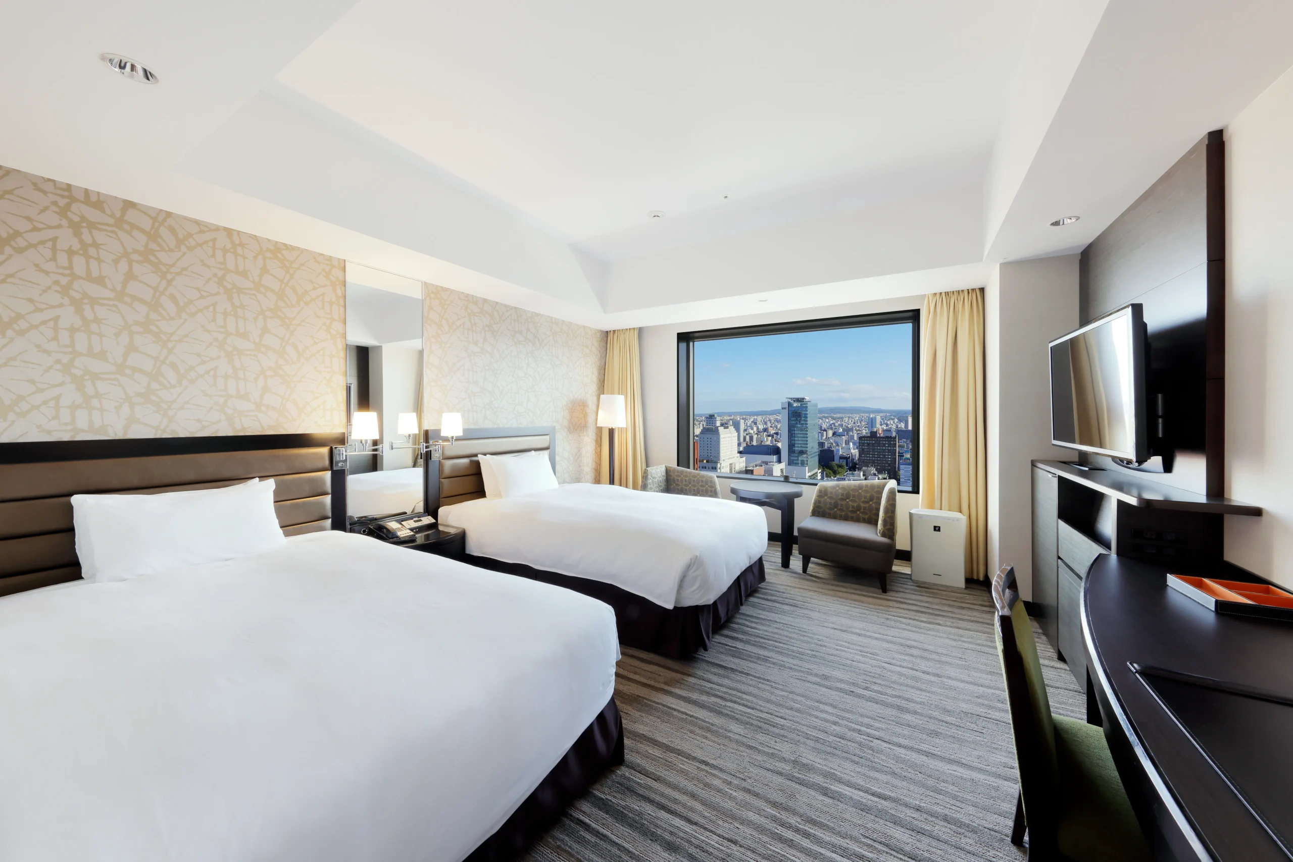 Twin room at JR Tower Hotel Nikko Sapporo with panoramic views of the Sapporo city skyline.