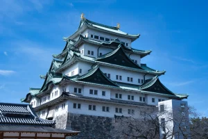 Historic Nagoya Castle with green rooftops under a clear blue sky