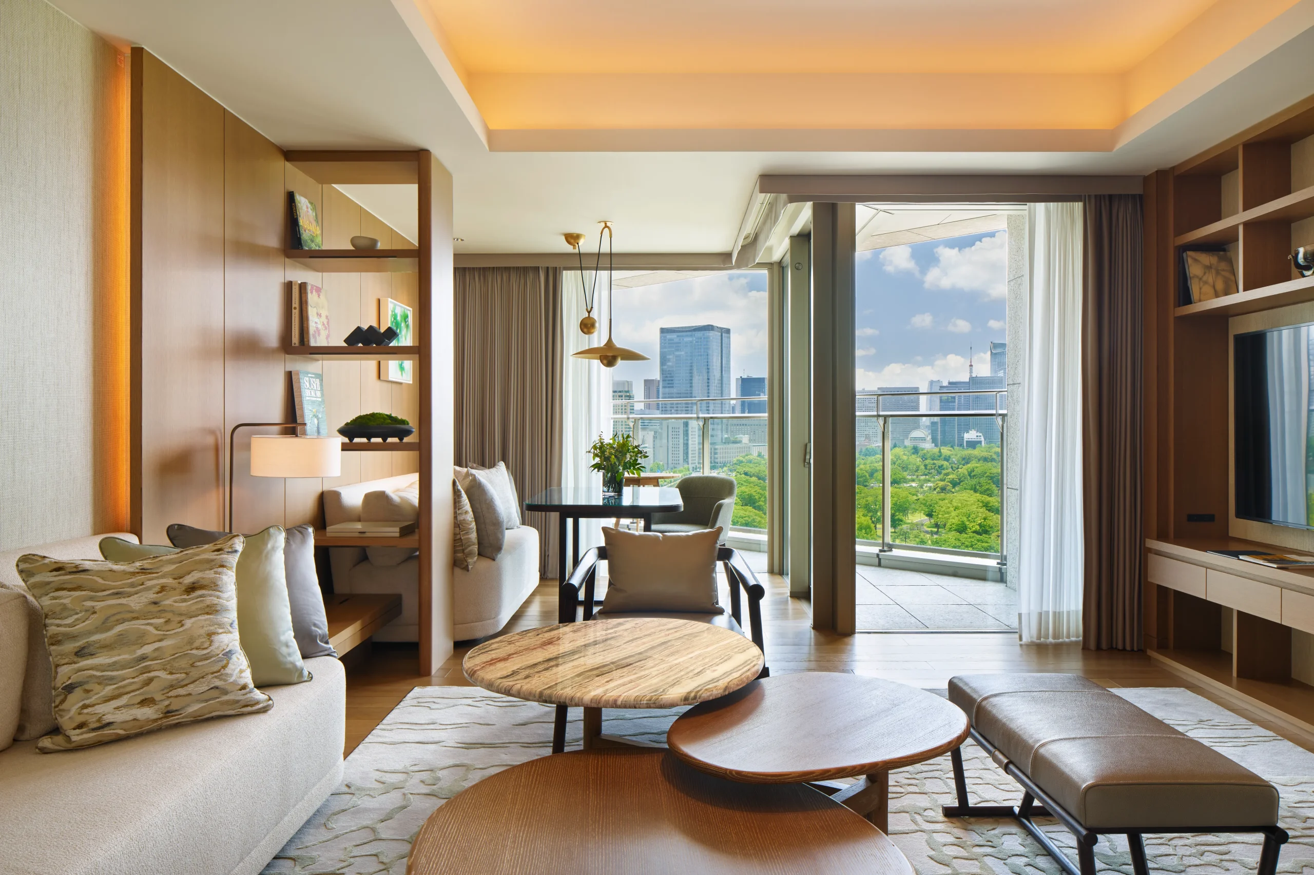 Stylish hotel suite at Palace Hotel Tokyo with floor-to-ceiling windows overlooking the greenery of the Imperial Palace.