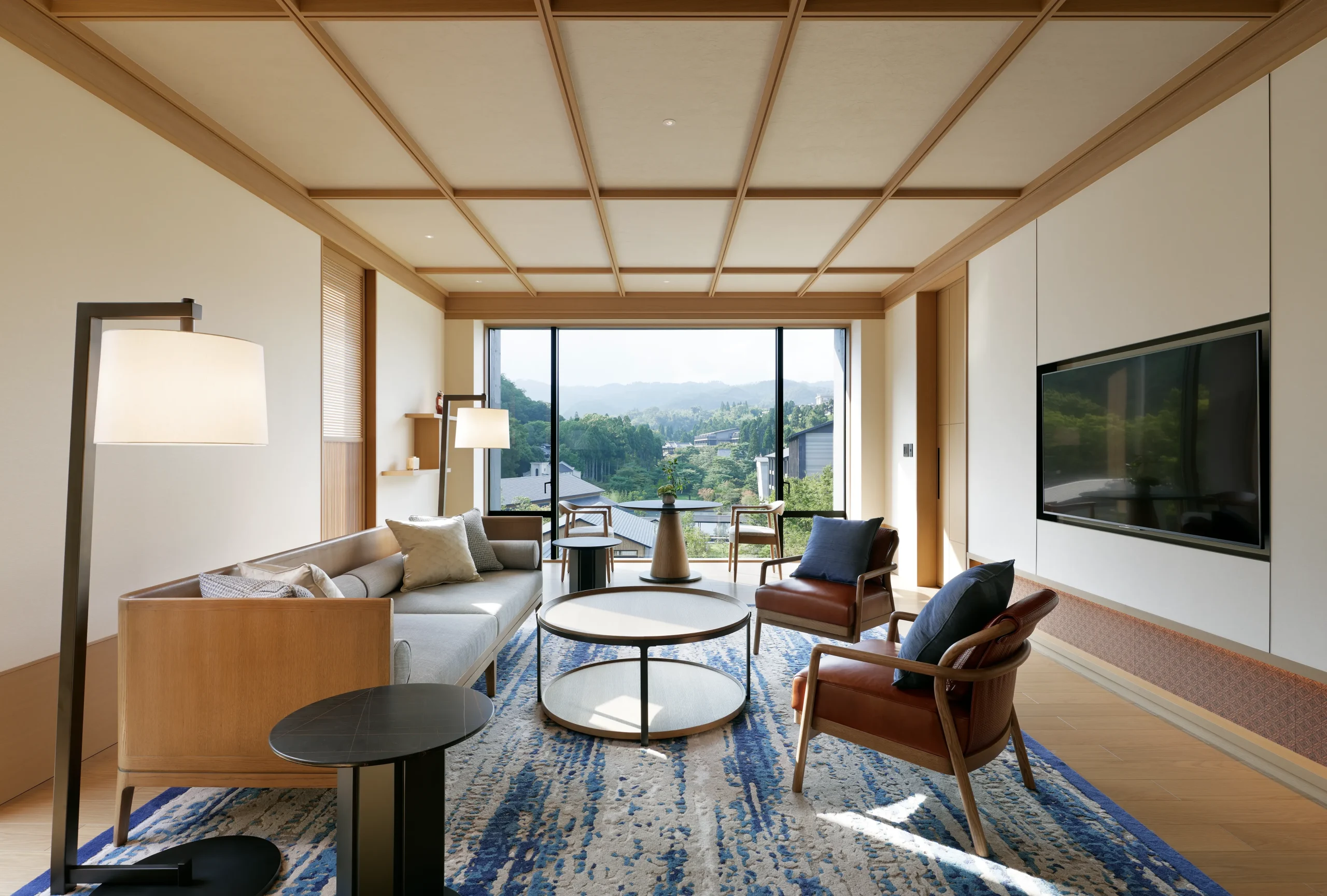 Stylish living room at ROKU KYOTO with scenic mountain view and modern Japanese décor.