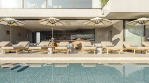Outdoor pool area at TRUNK (HOTEL) with sun loungers, parasols, and a stylish poolside bar.