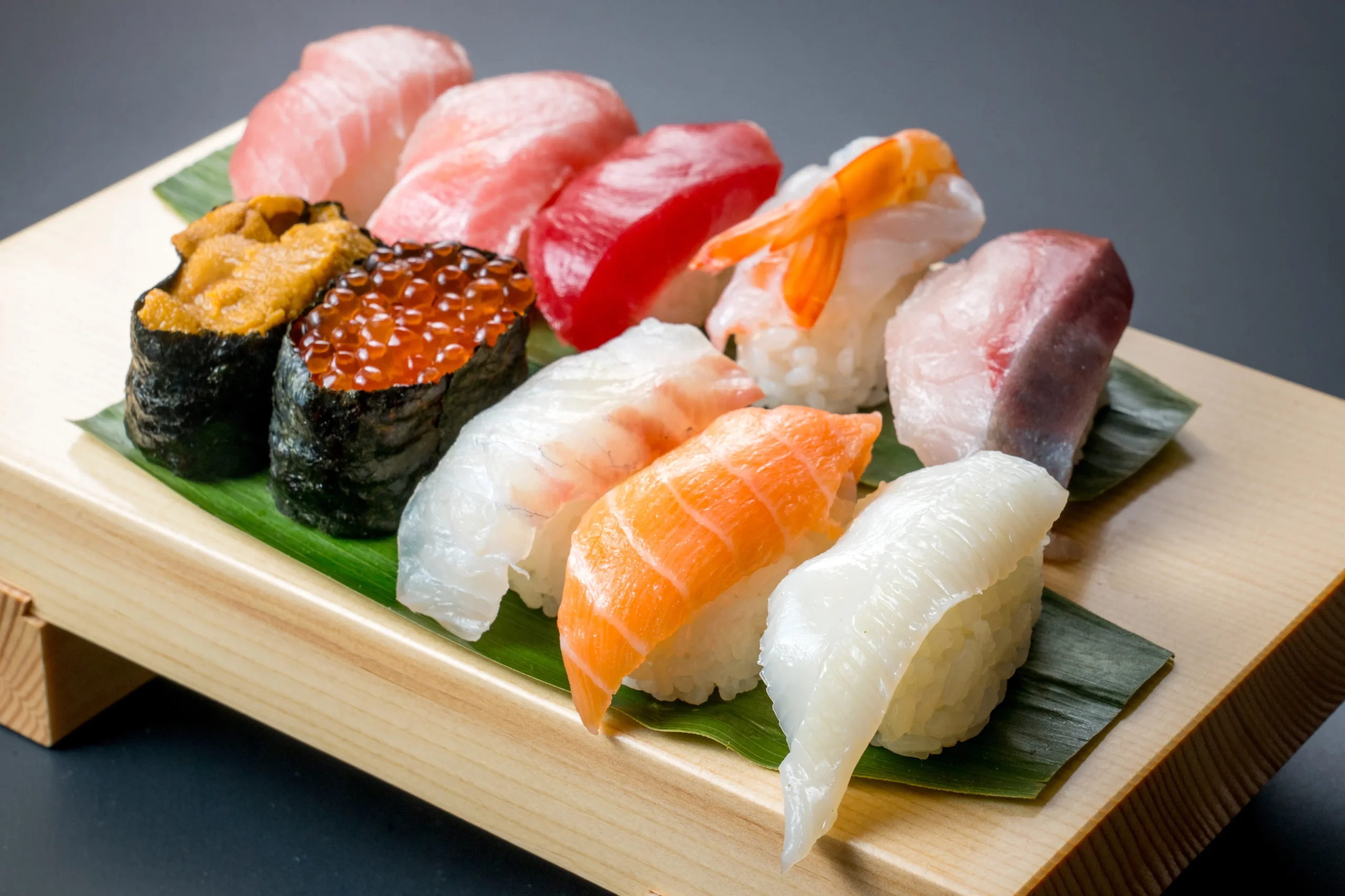 Traditional nigiri sushi assortment with uni, salmon, shrimp, and tuna