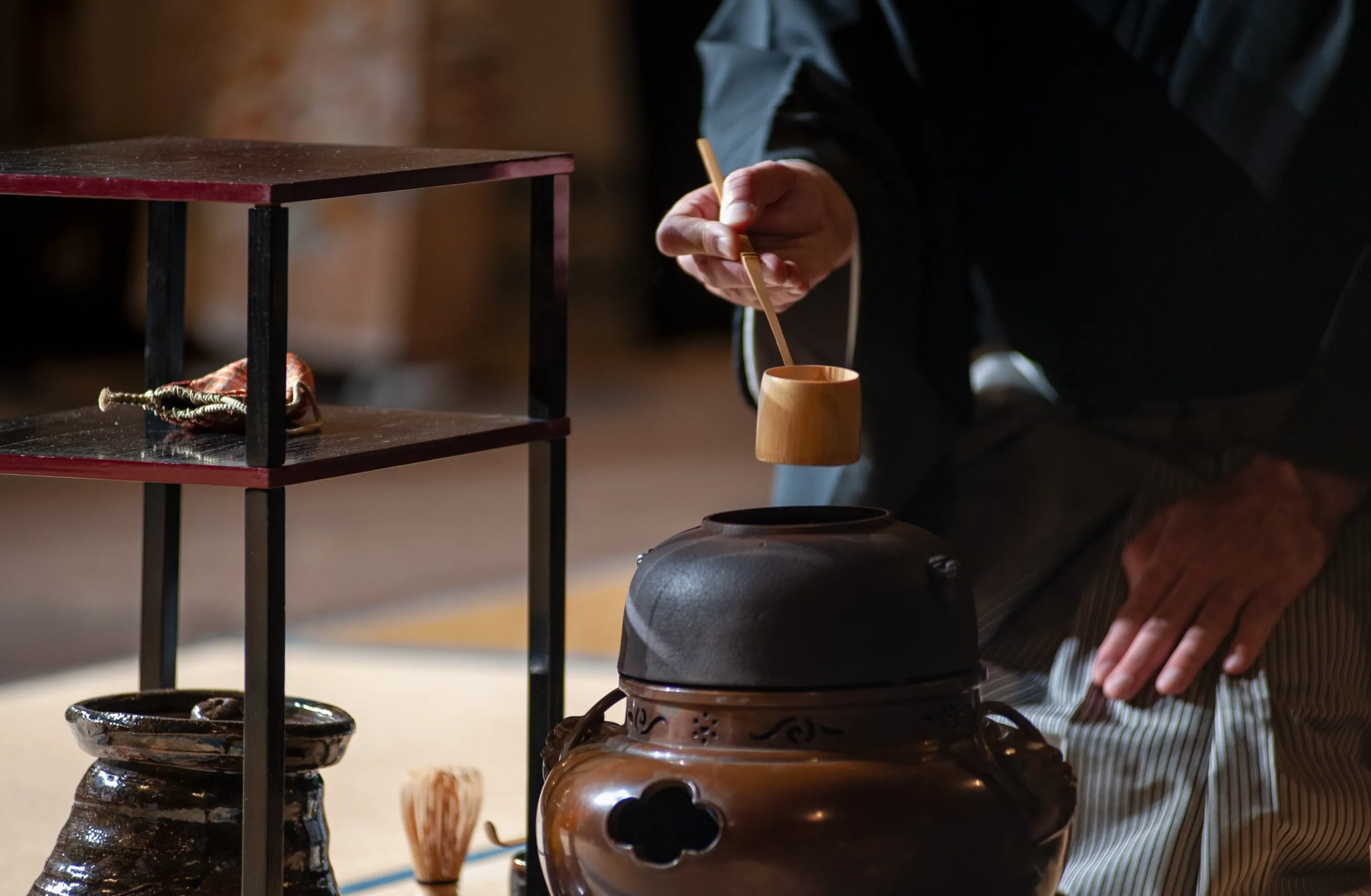 Traditional Japanese tea ceremony in action, preparing matcha with bamboo ladle