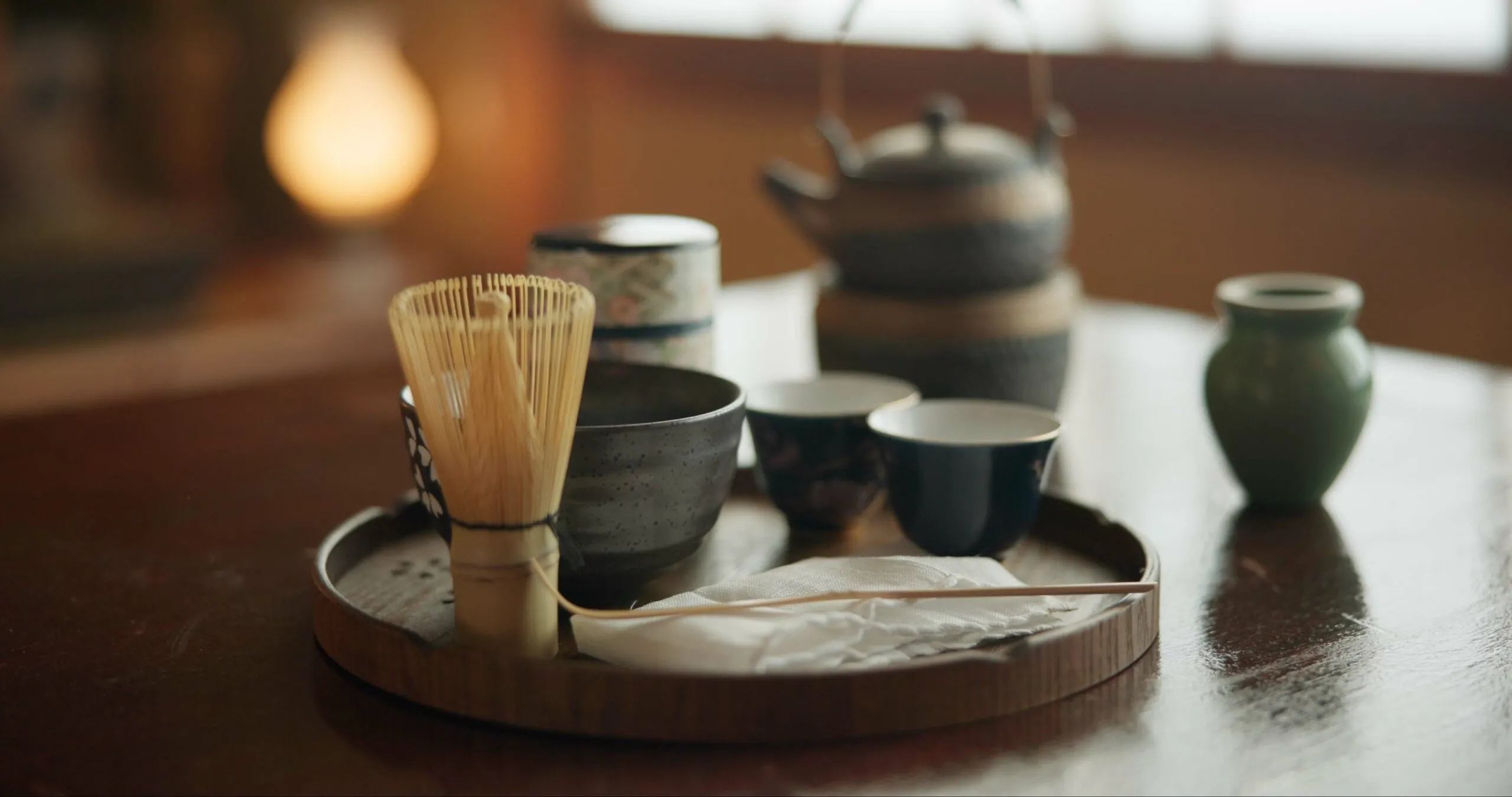 Matcha tea ceremony utensils including chasen whisk and tea bowls on a tray