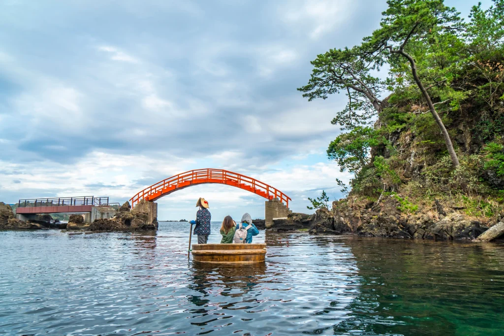 Traditional tub boat ride near red bridge in Sado Island, Niigata