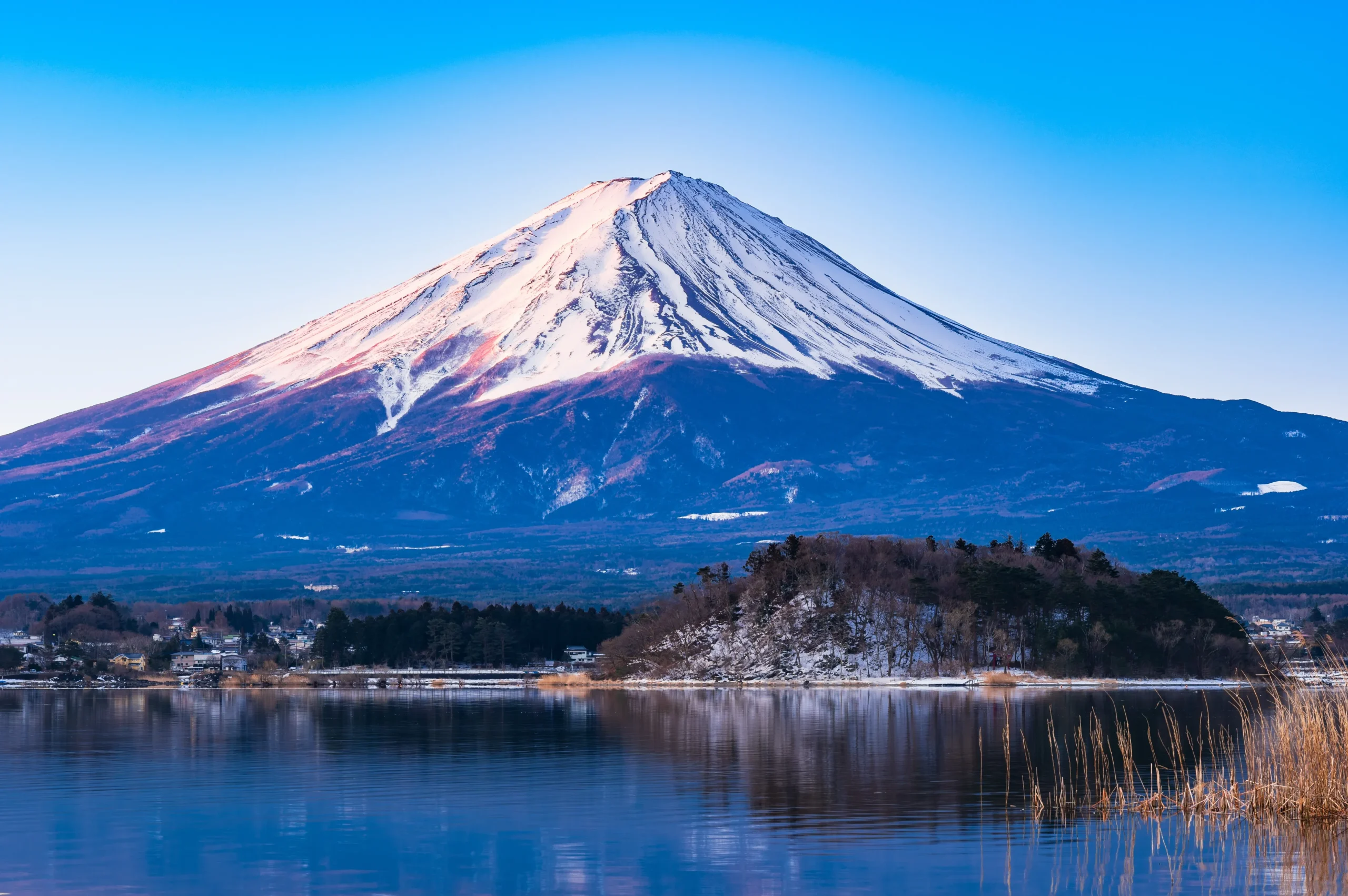 Snow-covered Mount Fuji reflecting on Lake Kawaguchi in winter, Yamanashi, Japan