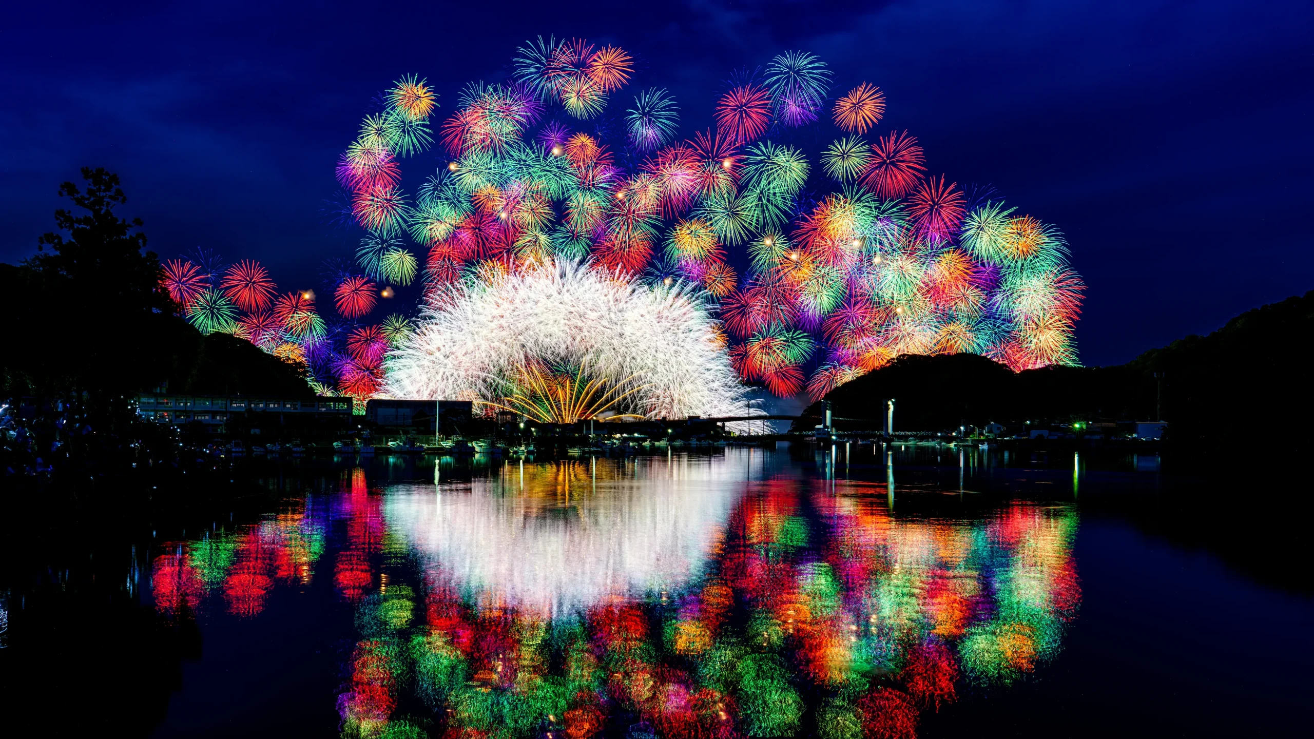 Colorful fireworks reflecting on river at Kihoku Lantern Festival in Mie, Japan