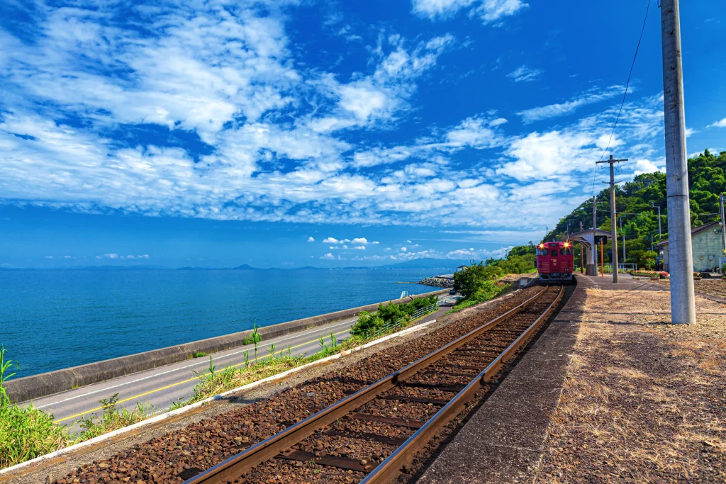 Local train traveling along the Iyo-nada coastline with blue sea and open sky