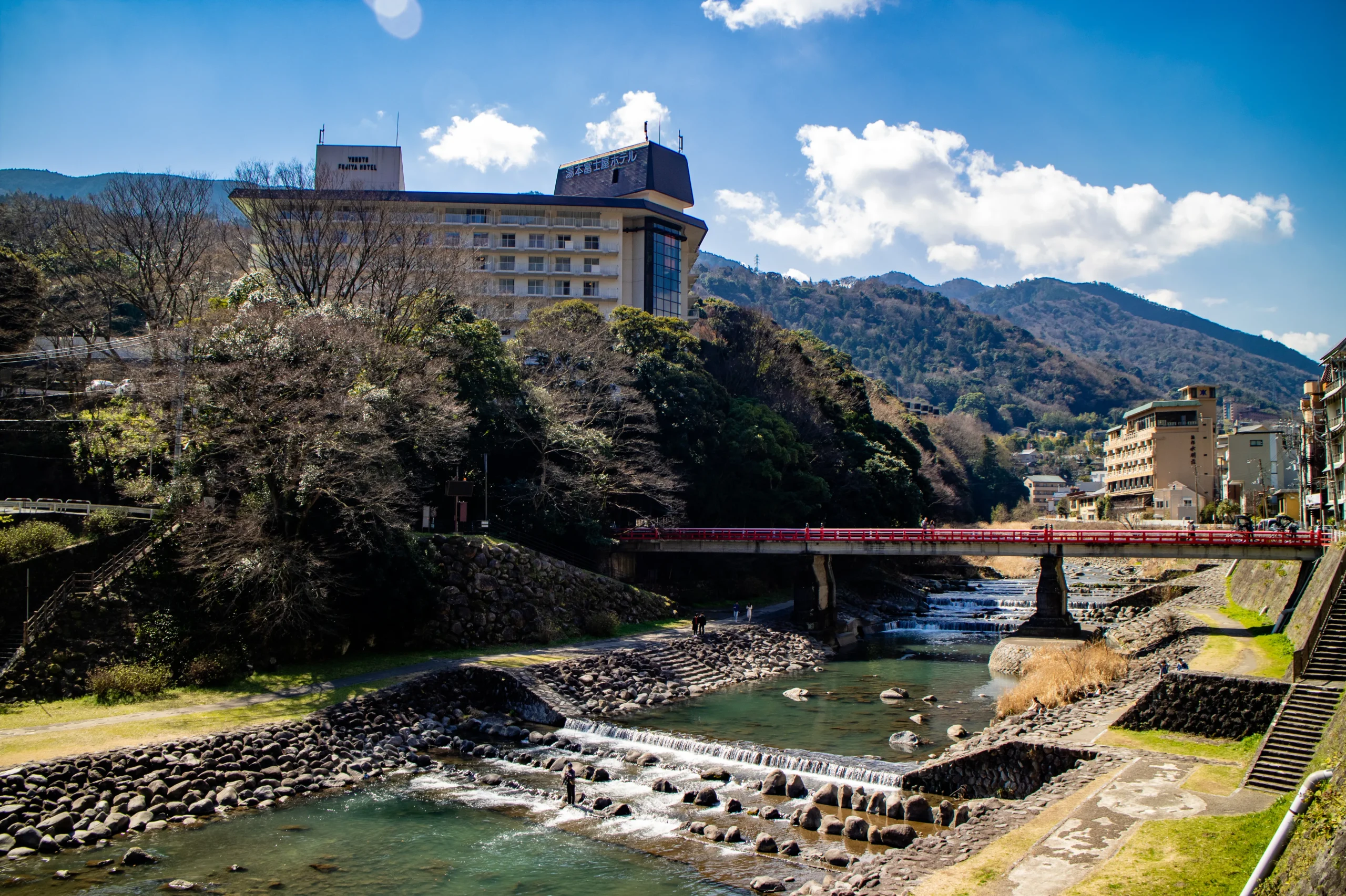 Red bridge over the Hayakawa River with mountain views in Hakone-Yumoto Onsen.