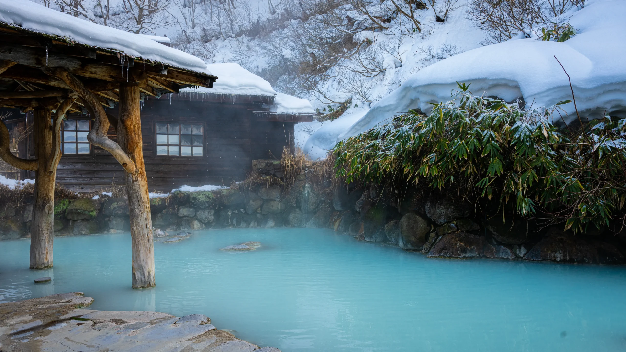 Milky blue outdoor hot spring bath (rotenburo) in the snow at Nyuto Onsen.