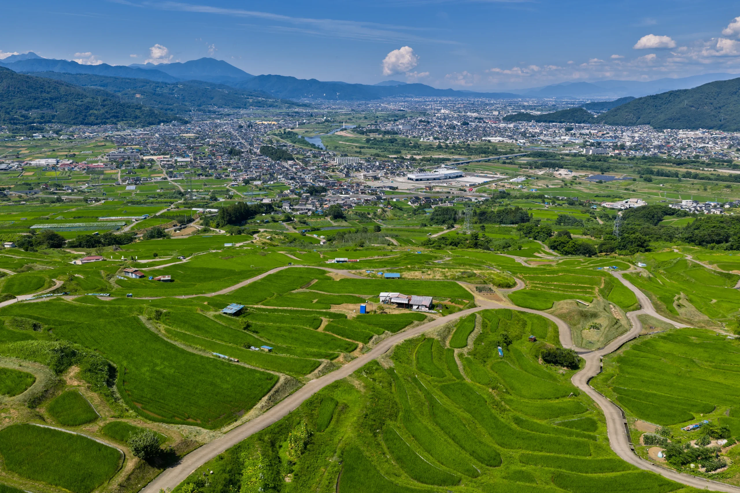 Panoramic view of the historic Obasute rice terraces overlooking Nagano's valley.