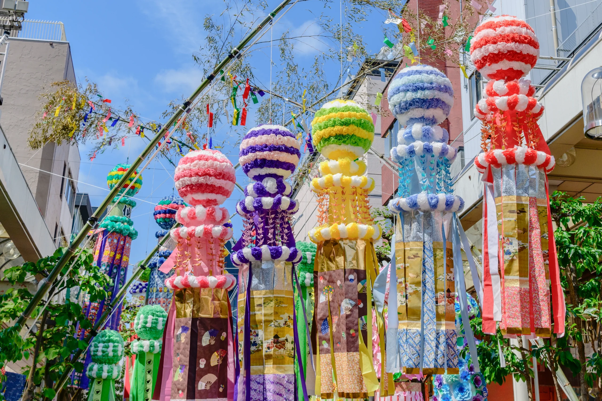 Colorful giant paper streamers hanging along a shopping street at Sendai Tanabata Festival.