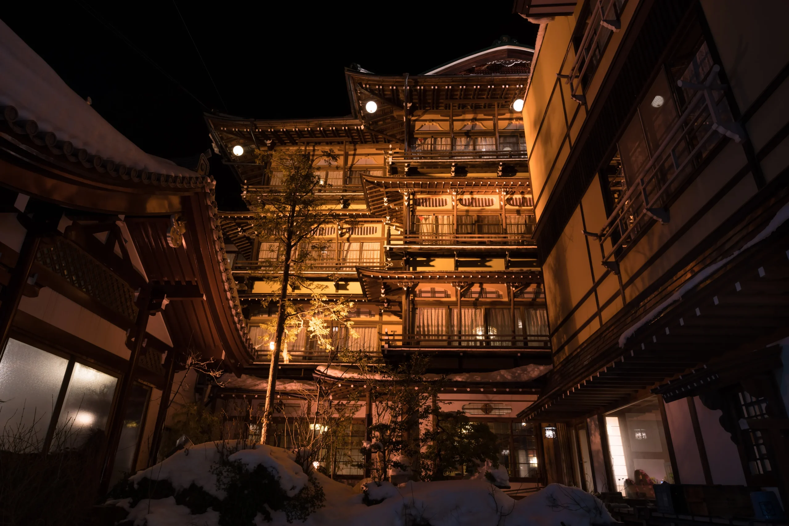 Wooden multi-story ryokan at Shibu Onsen on a snowy night