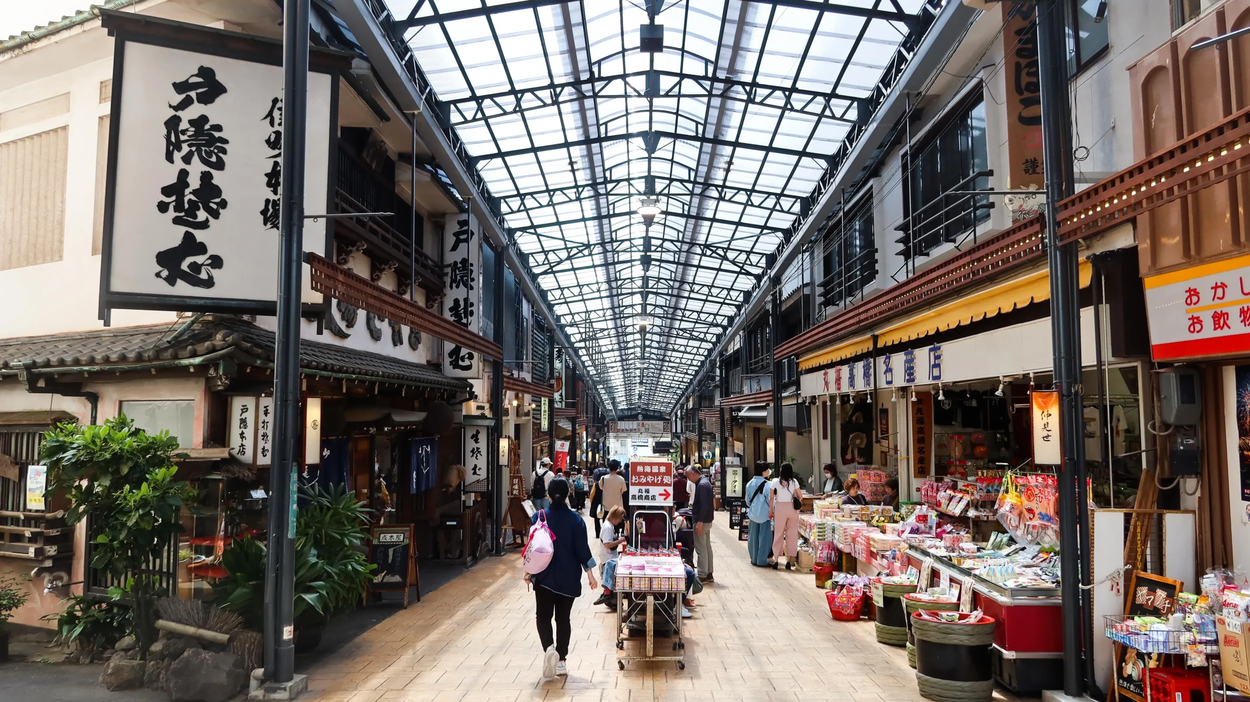 Shoppers in the covered retro shopping arcade at Atami Onsen