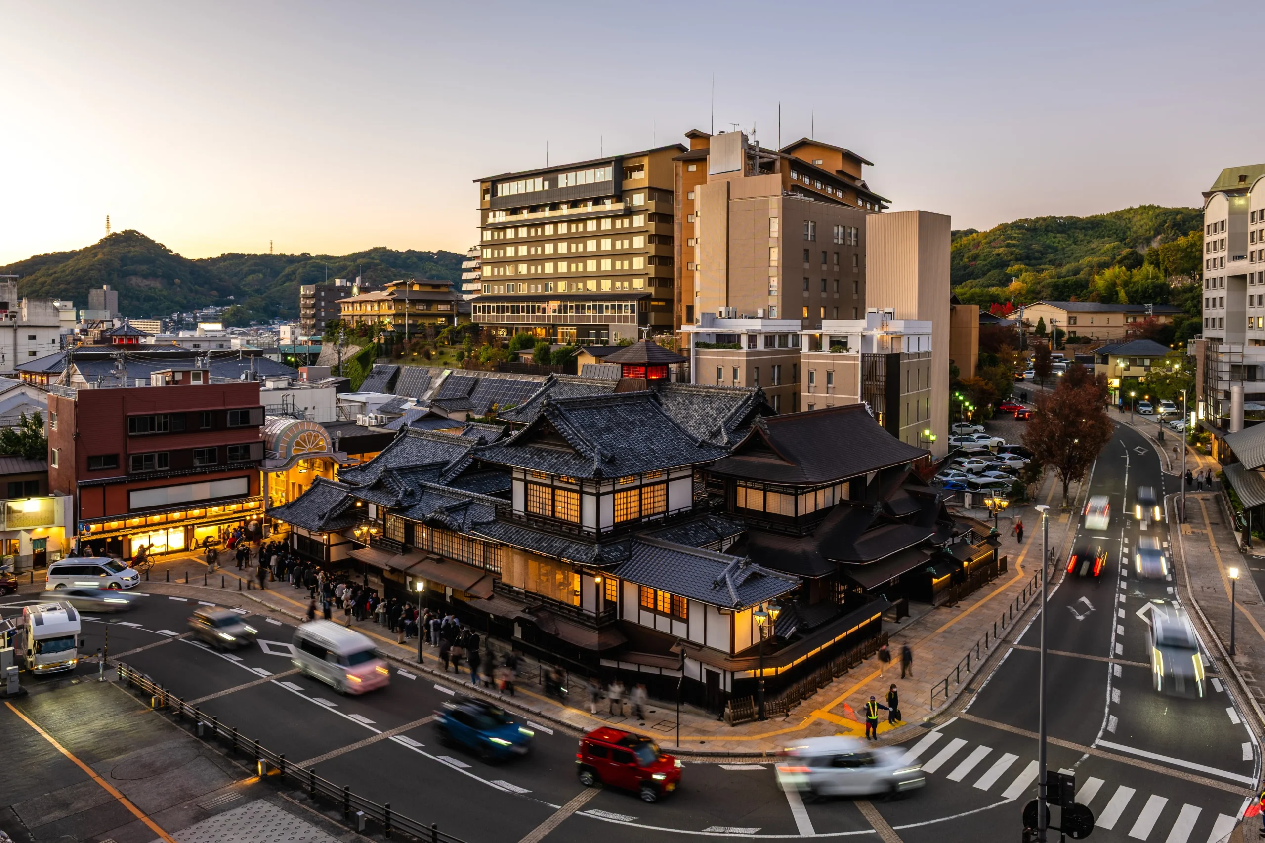Dogo Onsen Honkan bathhouse lit up at dusk, Matsuyama