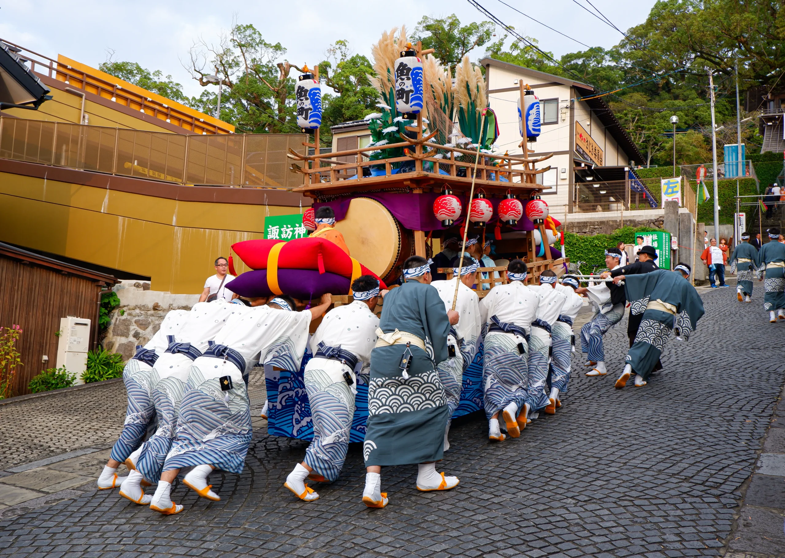 Nagasaki Kunchi festival with float procession and participants pulling cart uphill