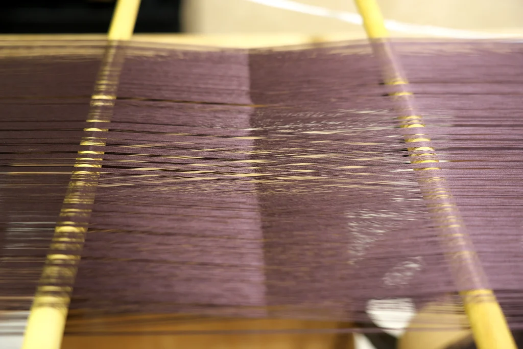 Nishijin textile weaving process in Kyoto with silk threads on traditional loom