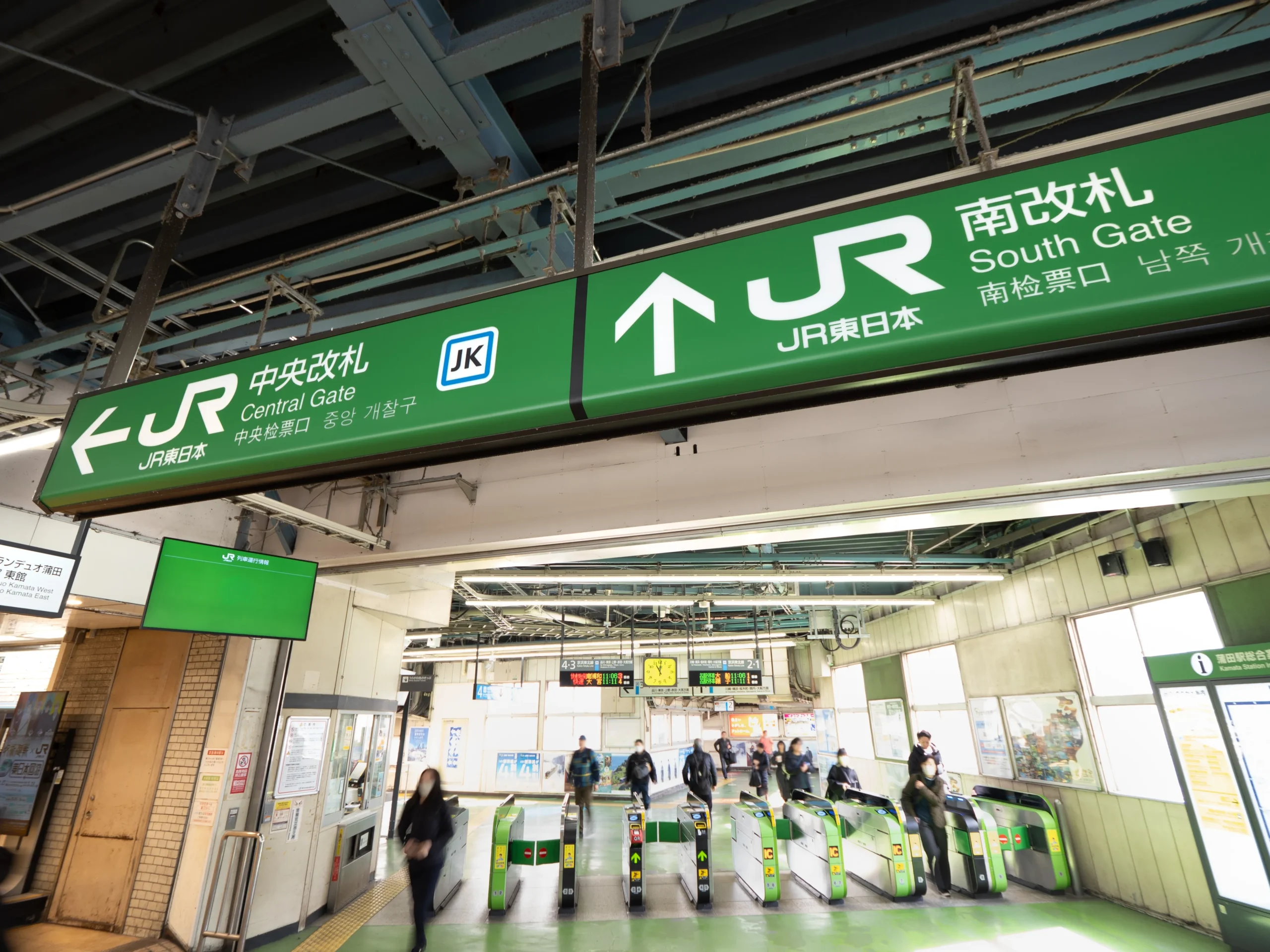 JR station ticket gates in Tokyo with Central and South Gate signs and commuters