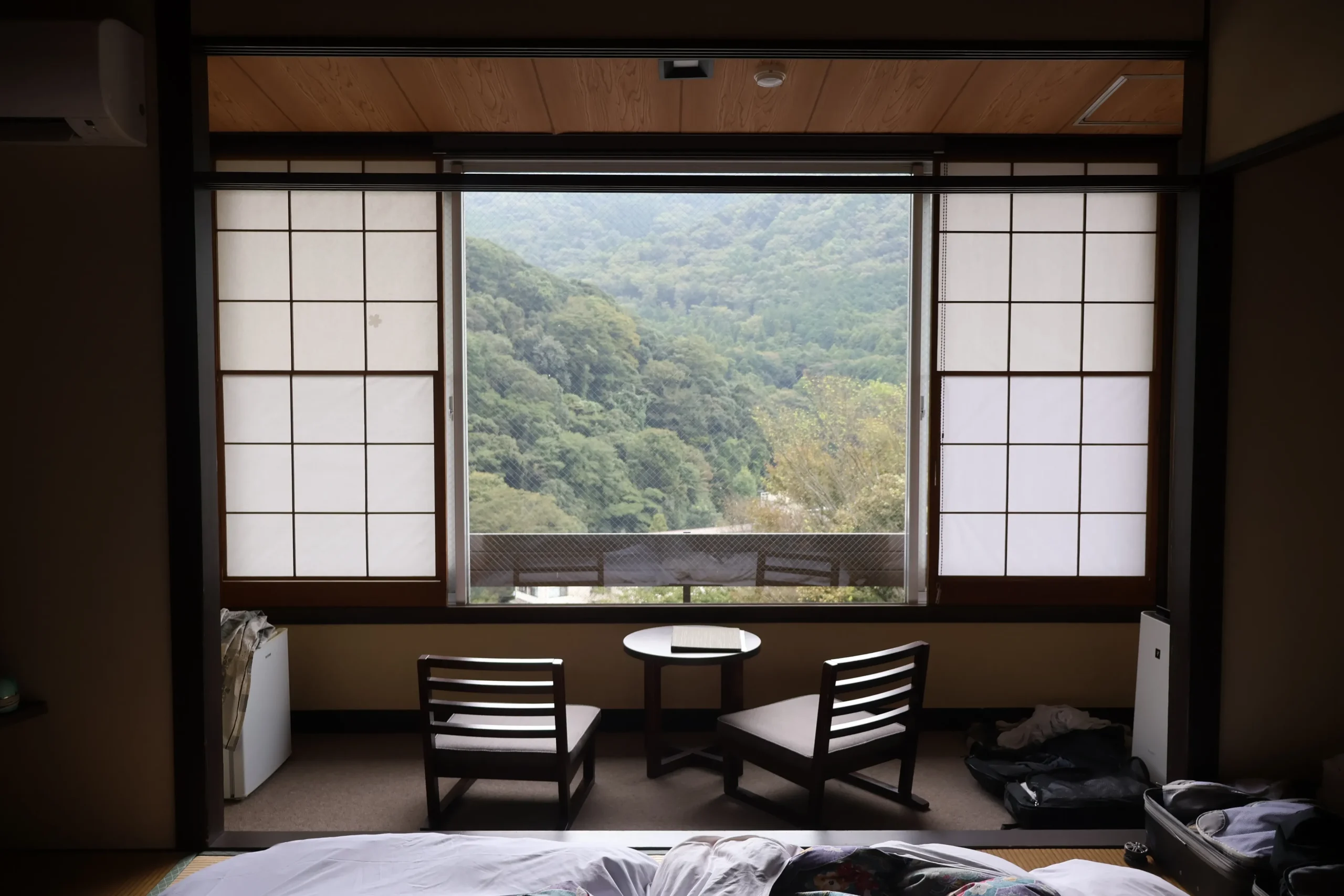 Ryokan room in Japan with shoji screens, mountain view and low table seating