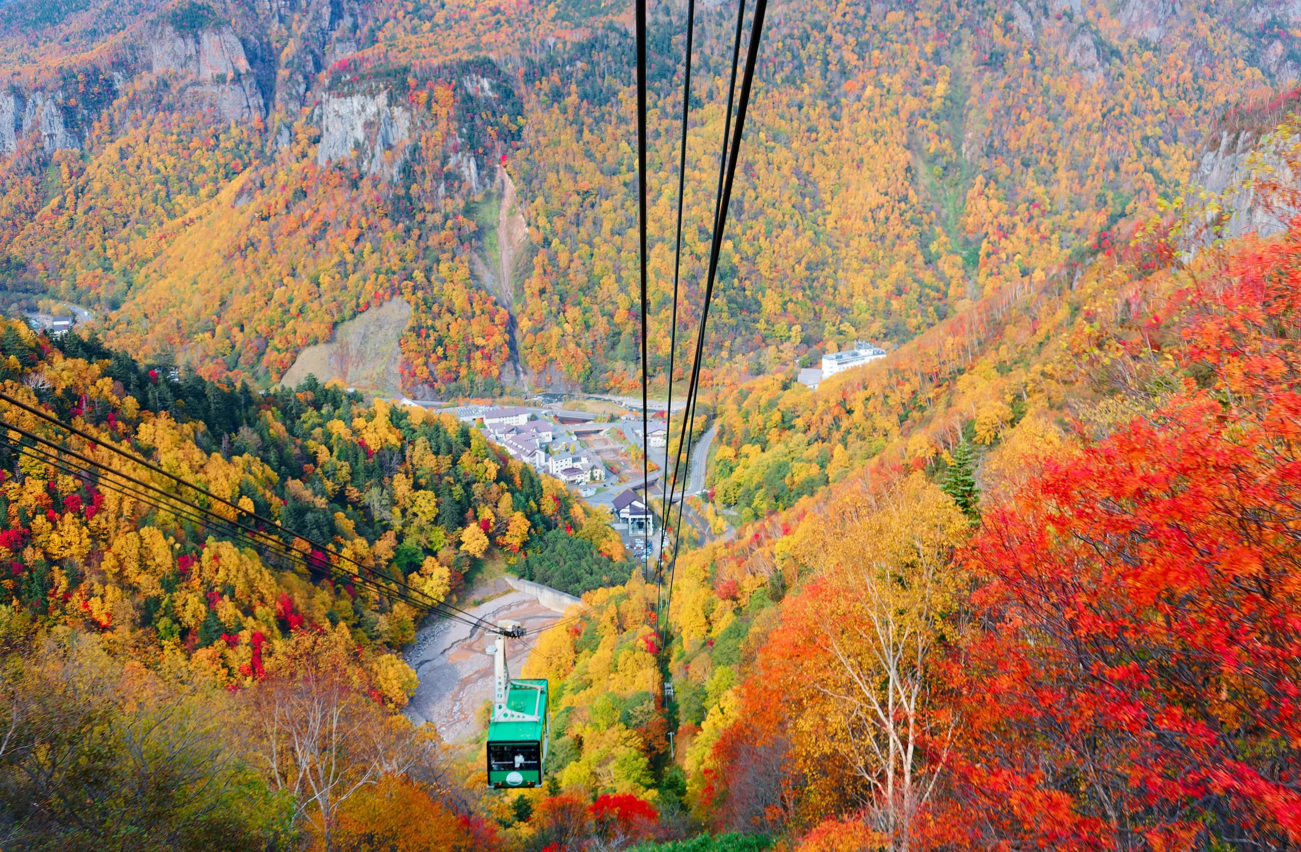 Ropeway view over Daisetsuzan National Park covered in vibrant autumn foliage in Hokkaido