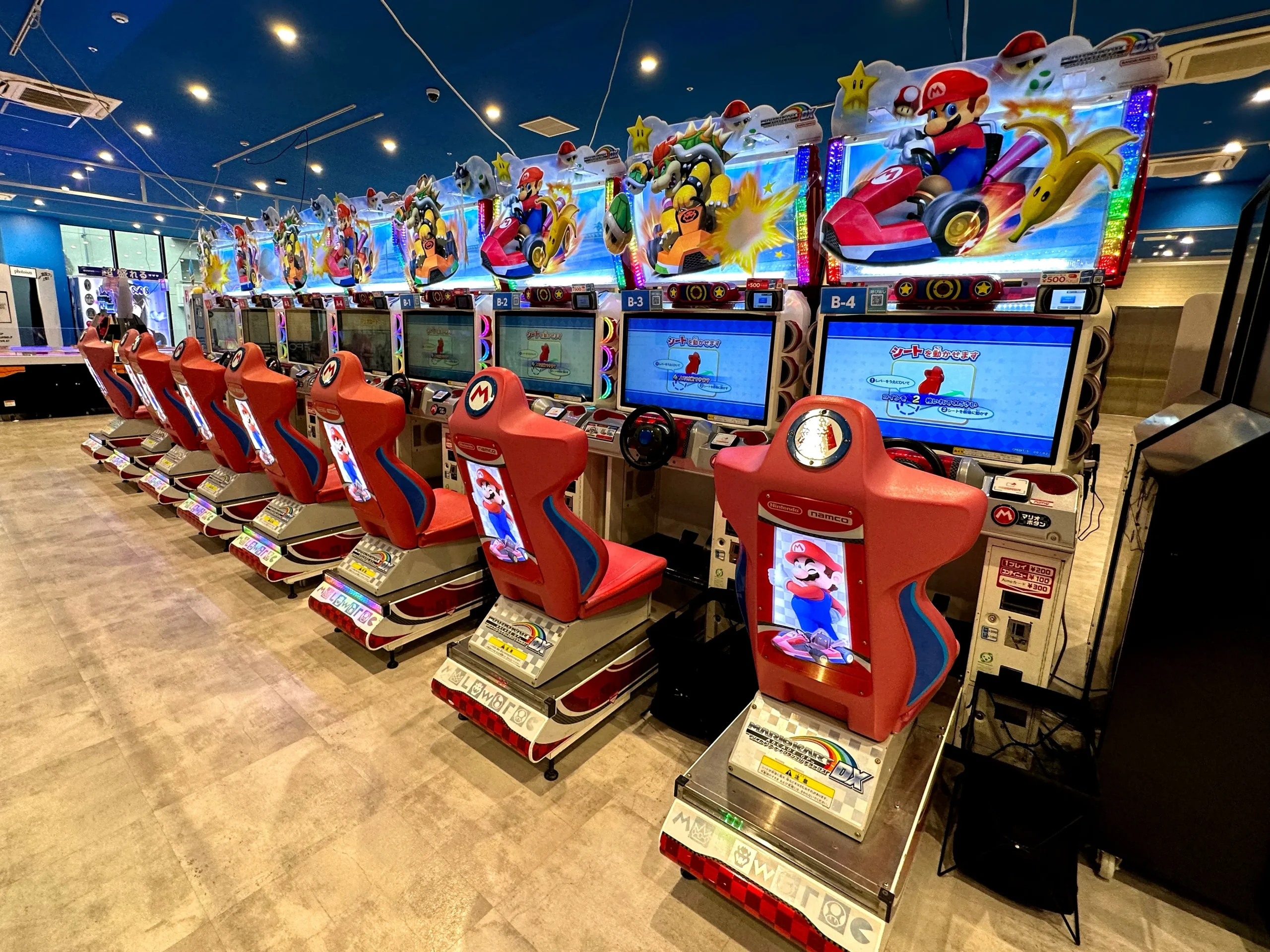 Rows of Mario Kart arcade machines inside a lively Japanese game center in Ikebukuro