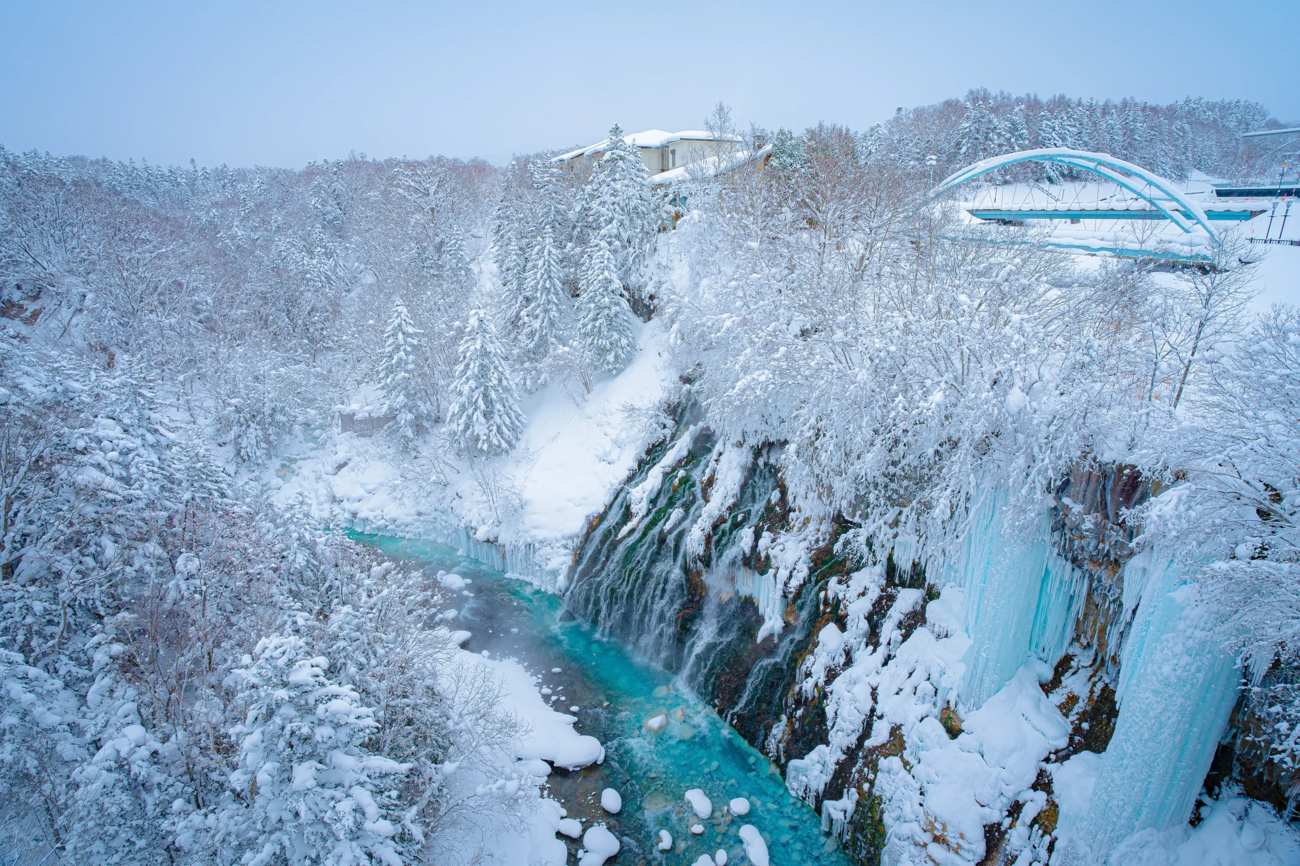 Frozen waterfall and snowy forest landscape in Hokkaido during winter