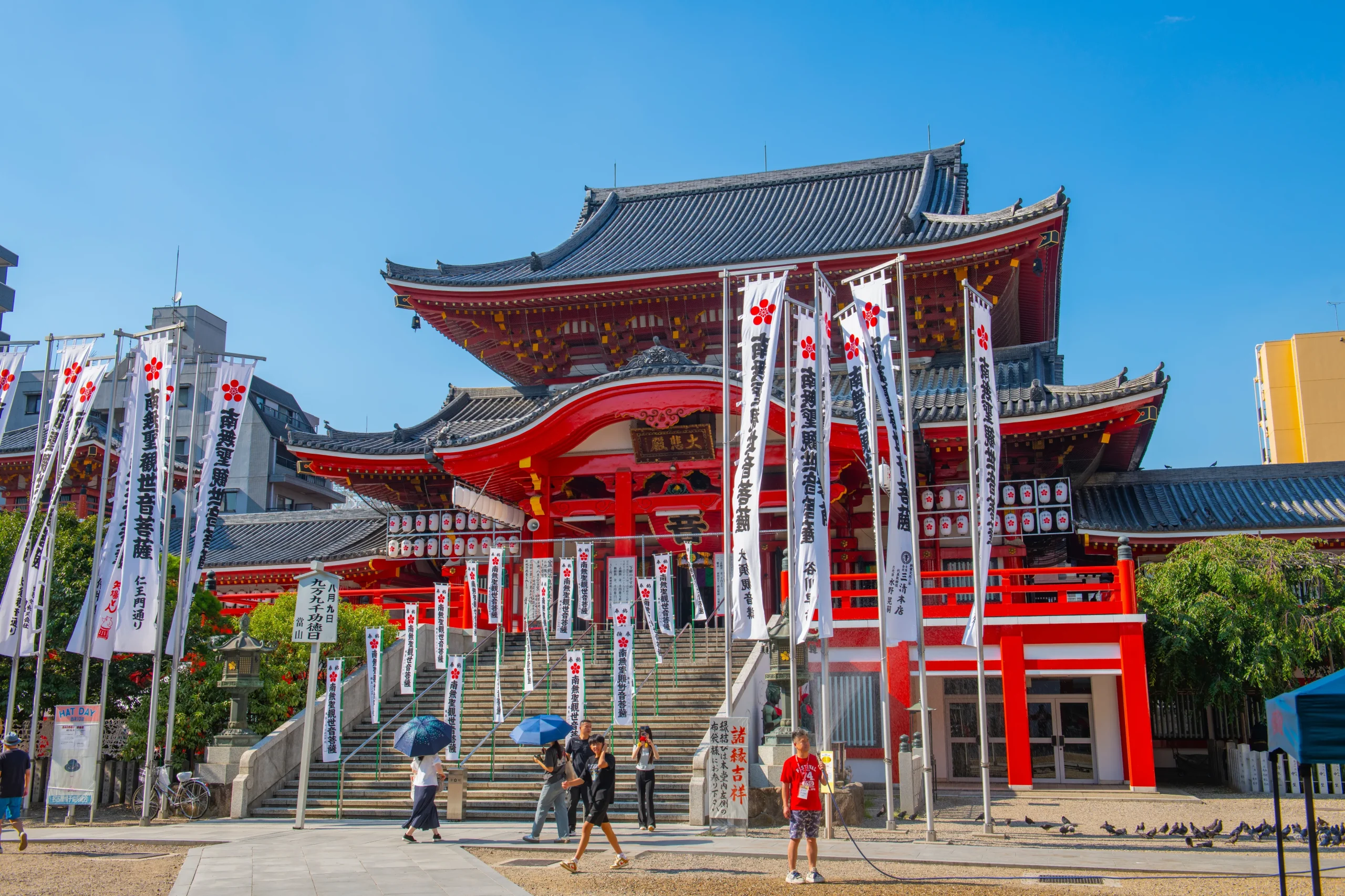 Osu Kannon Temple in Nagoya with bright red architecture and festival banners under a blue sky