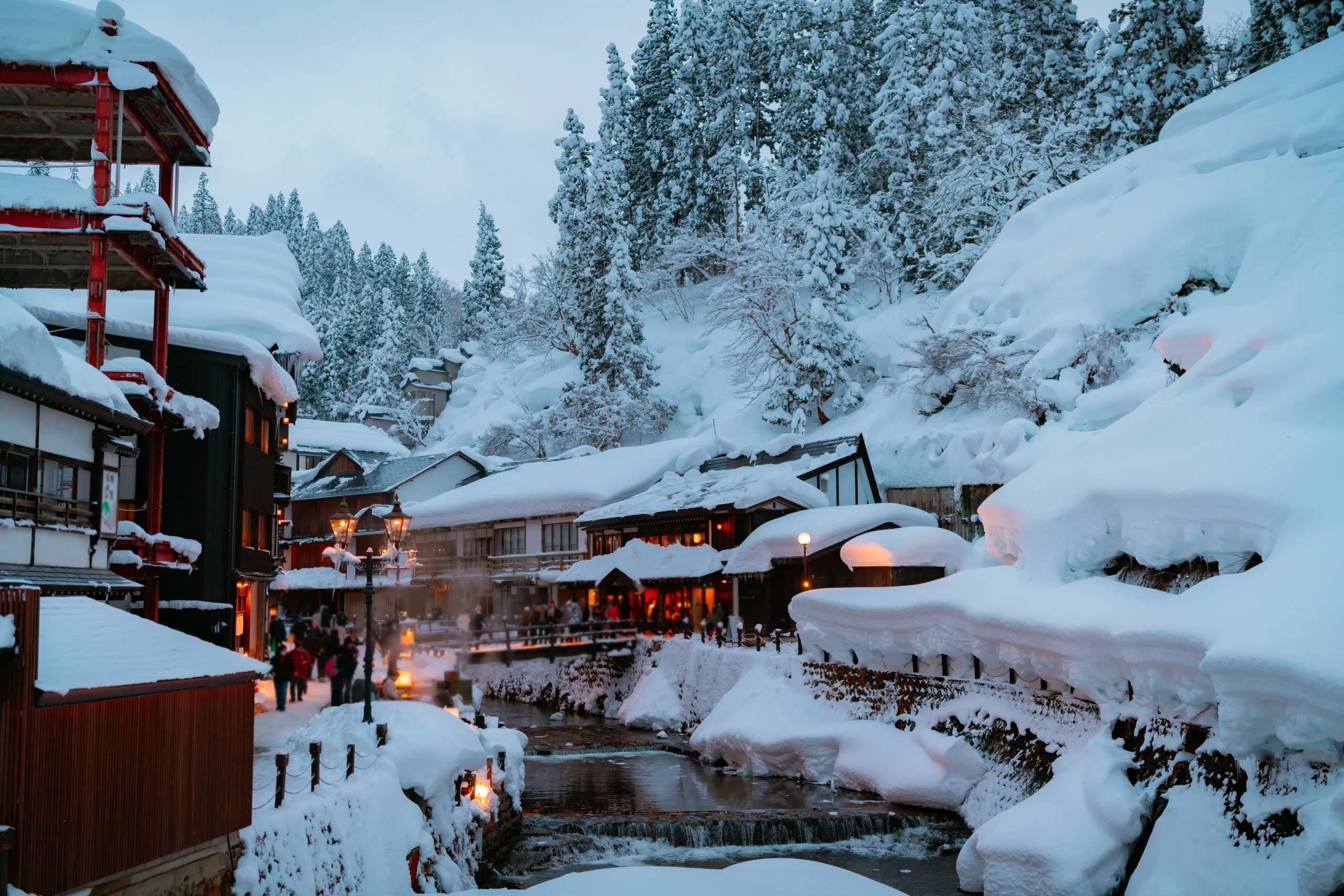 Snow-covered Ginzan Onsen hot spring town in winter with glowing lanterns and traditional ryokan