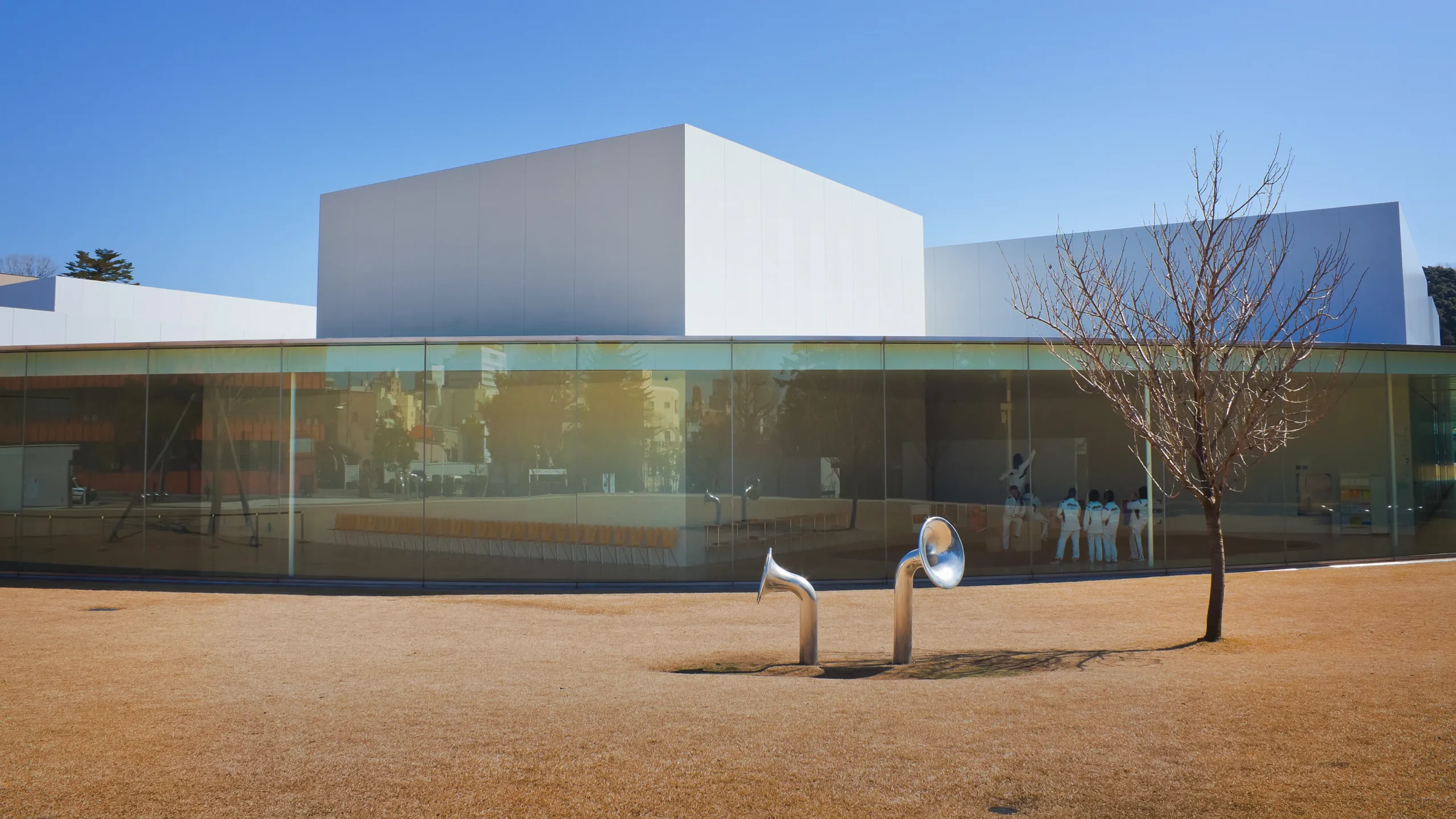 Glass facade and outdoor sculptures at the 21st Century Museum of Contemporary Art, Kanazawa
