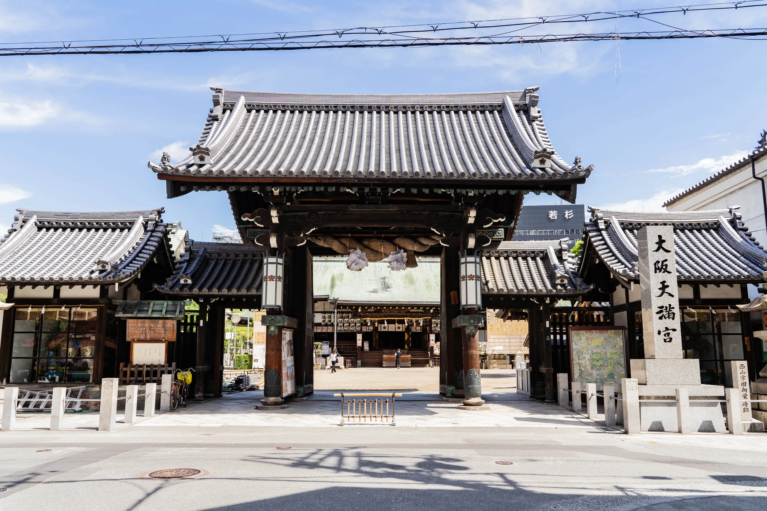 Main gate with shimenawa rope at Osaka Tenmangu Shrine under a blue sky