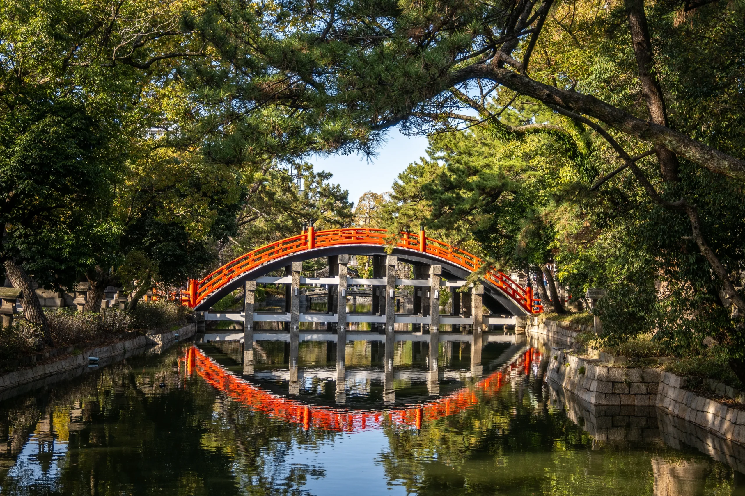Red arched Sorihashi bridge reflected in the pond at Sumiyoshi Taisha, Osaka