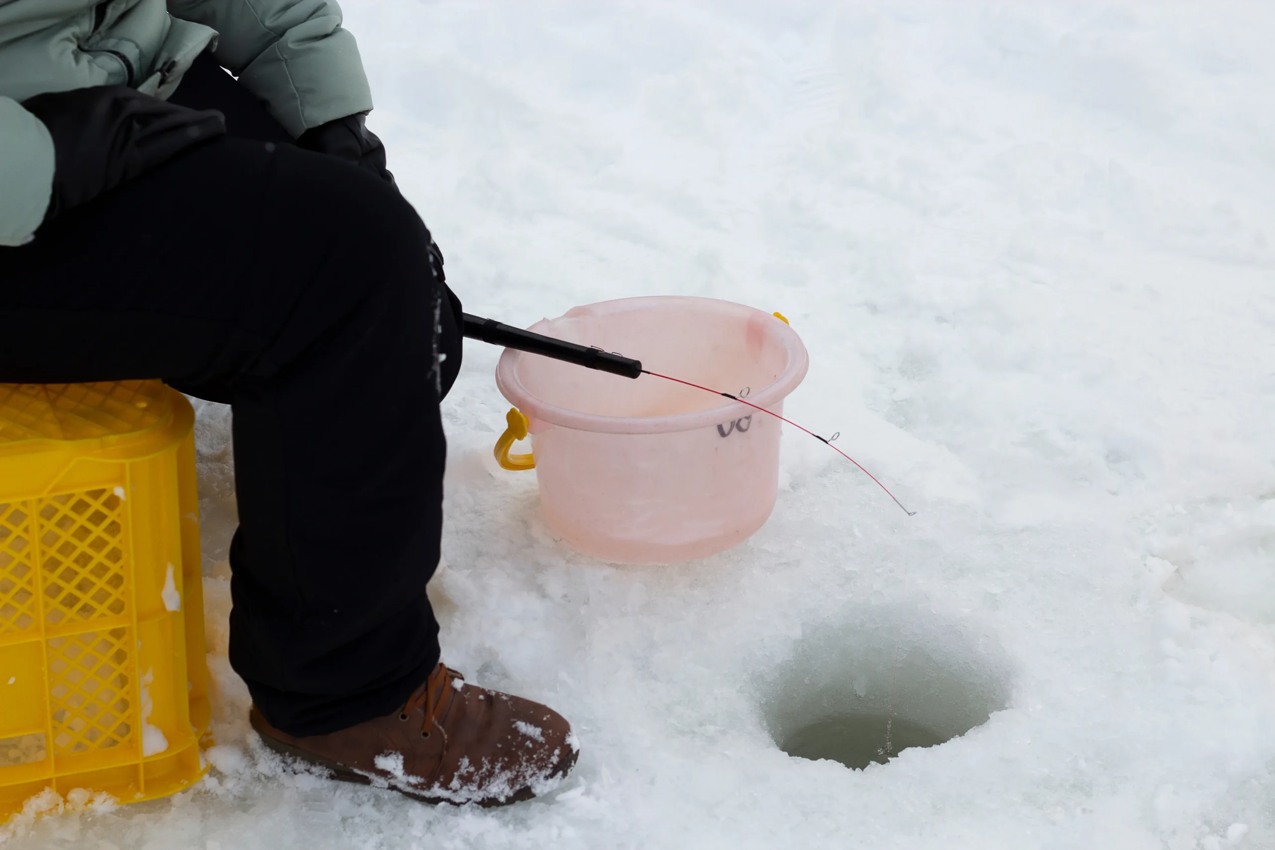 Wakasagi smelt ice fishing through a hole on a frozen lake in Hokkaido