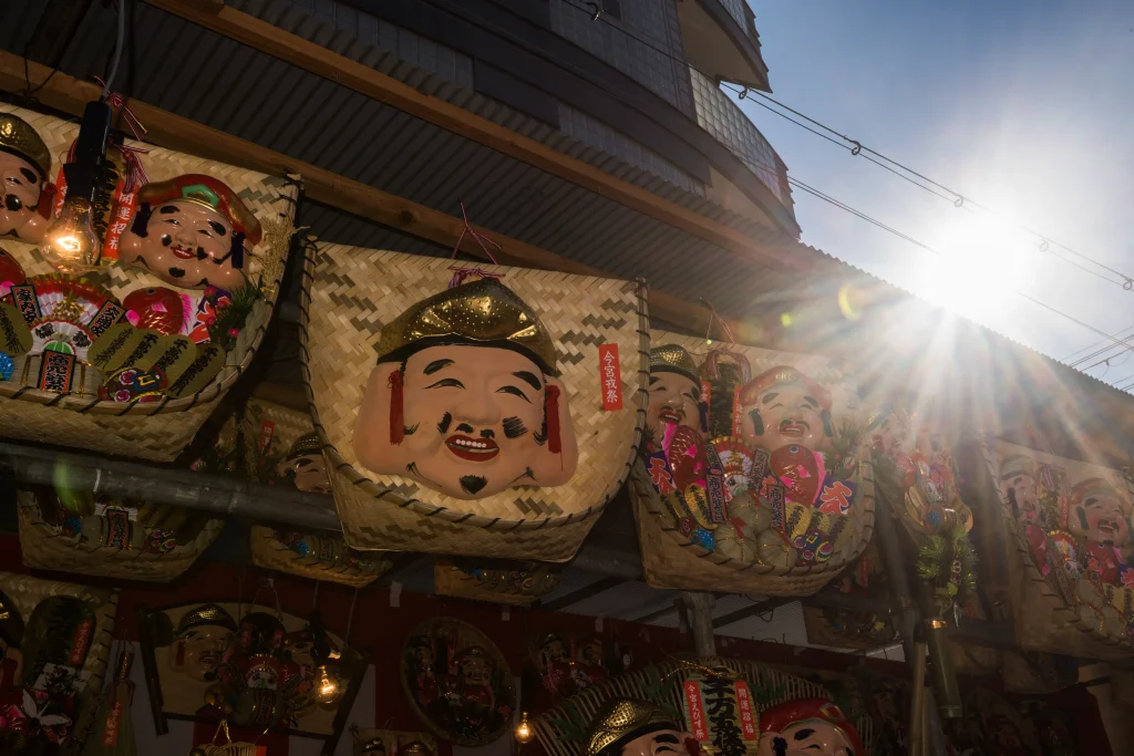 Ebisu god masks on bamboo baskets sold as good-luck charms at a Japanese New Year shrine festival.
