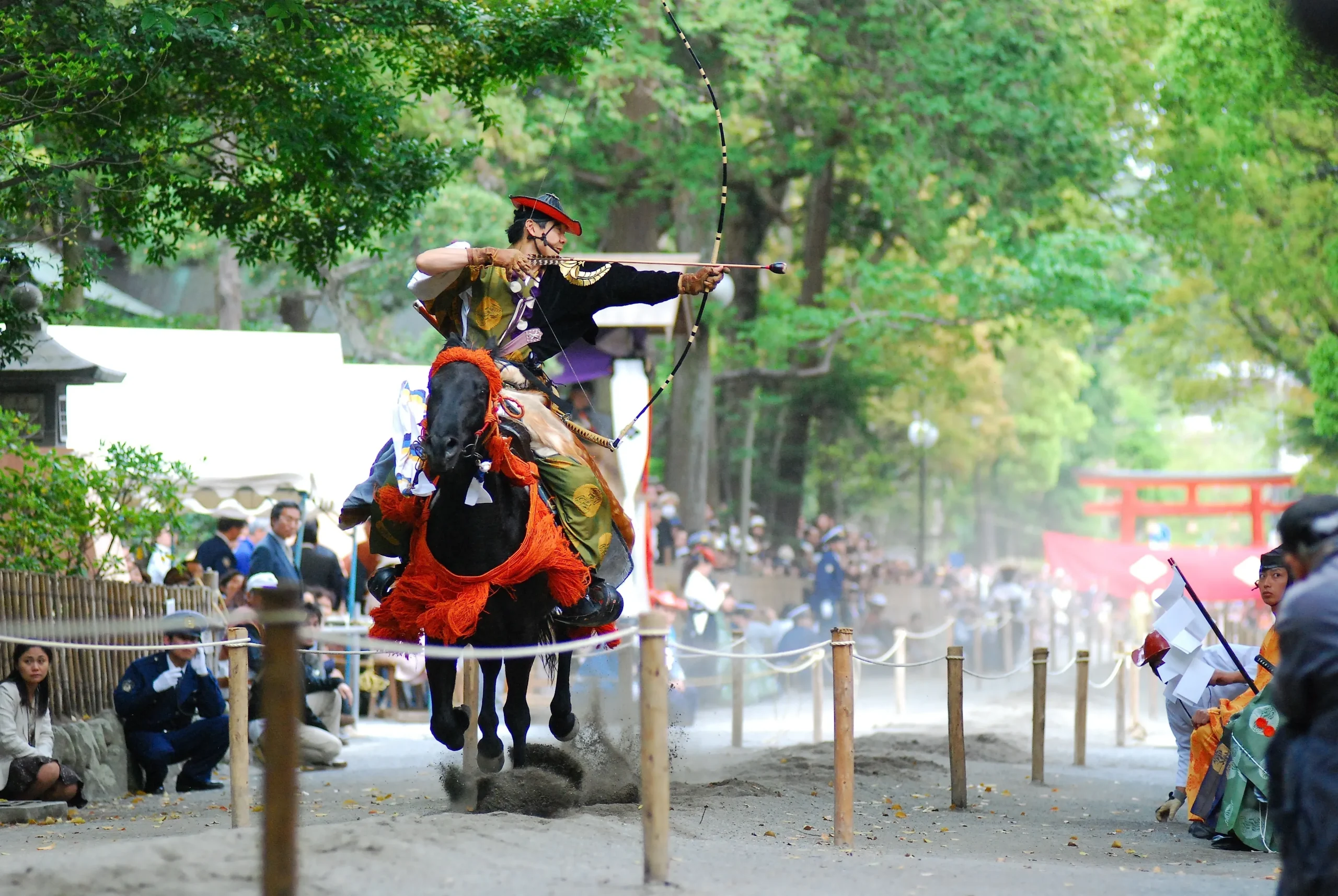 Yabusame horseback archer in traditional dress draws his bow at full gallop during a shrine festival in Kamakura.