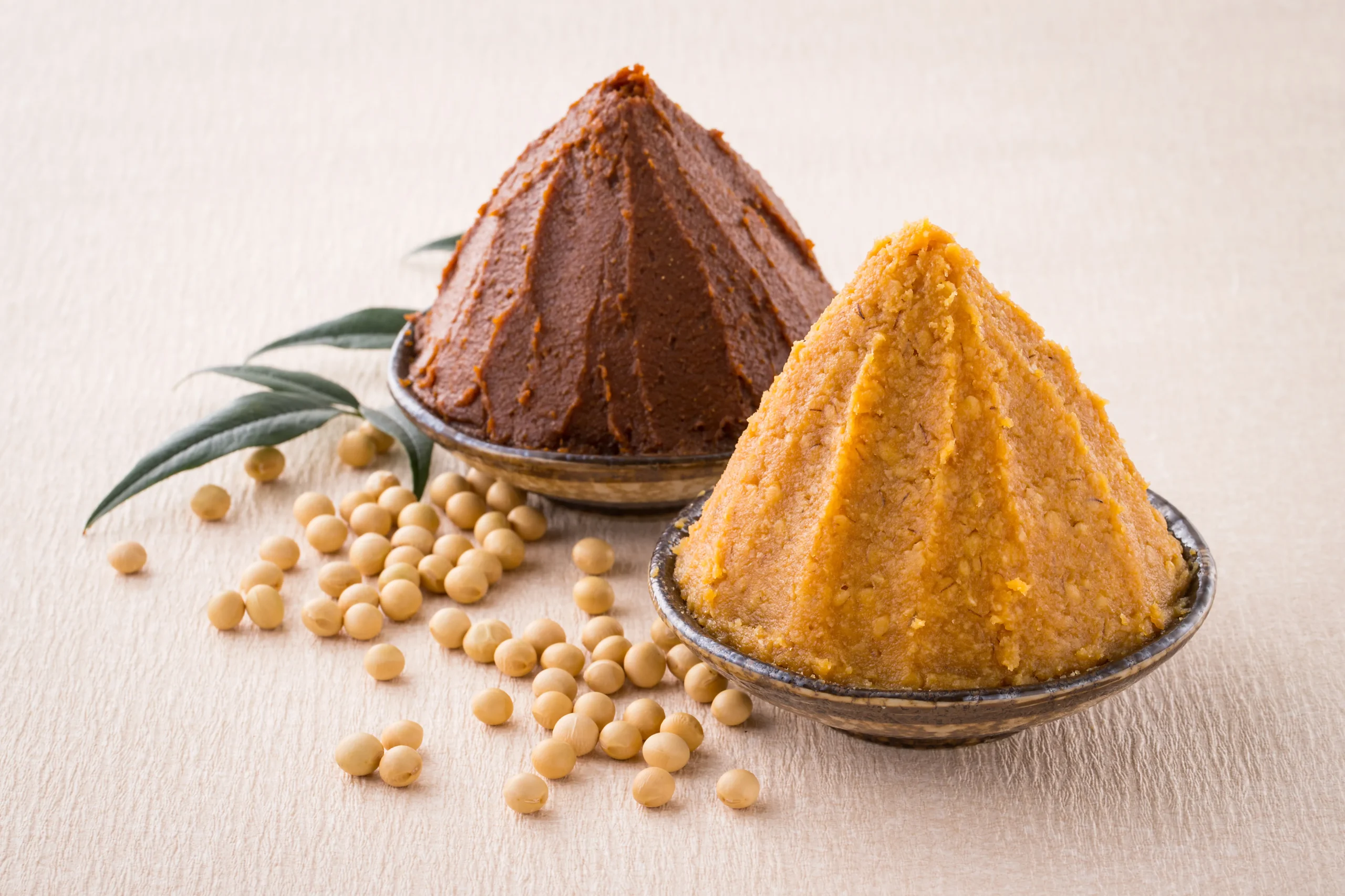 Red and white miso paste in bowls with soybeans