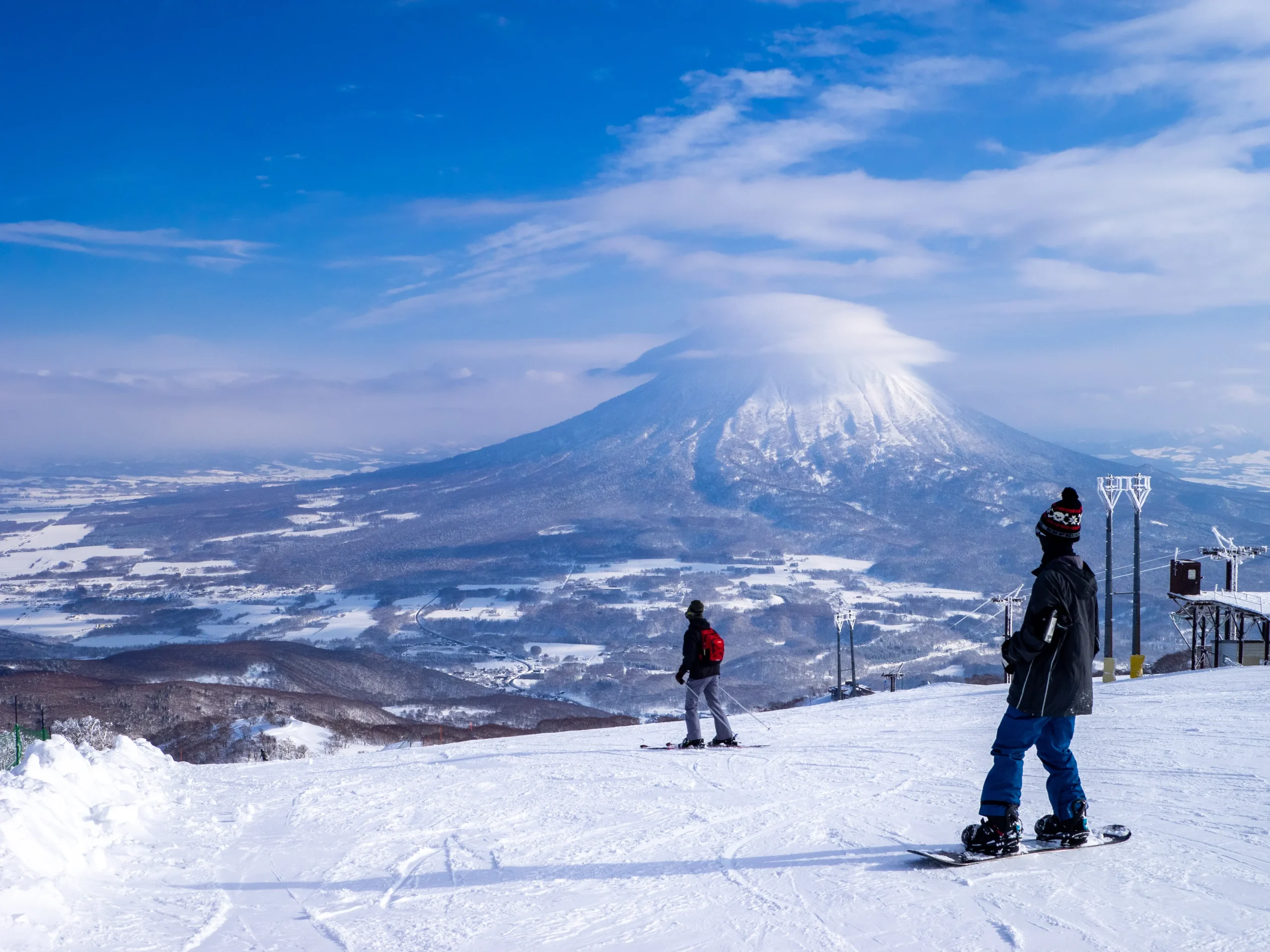 Skiers and snowboarders at Niseko ski resort with Mt. Yotei in Hokkaido