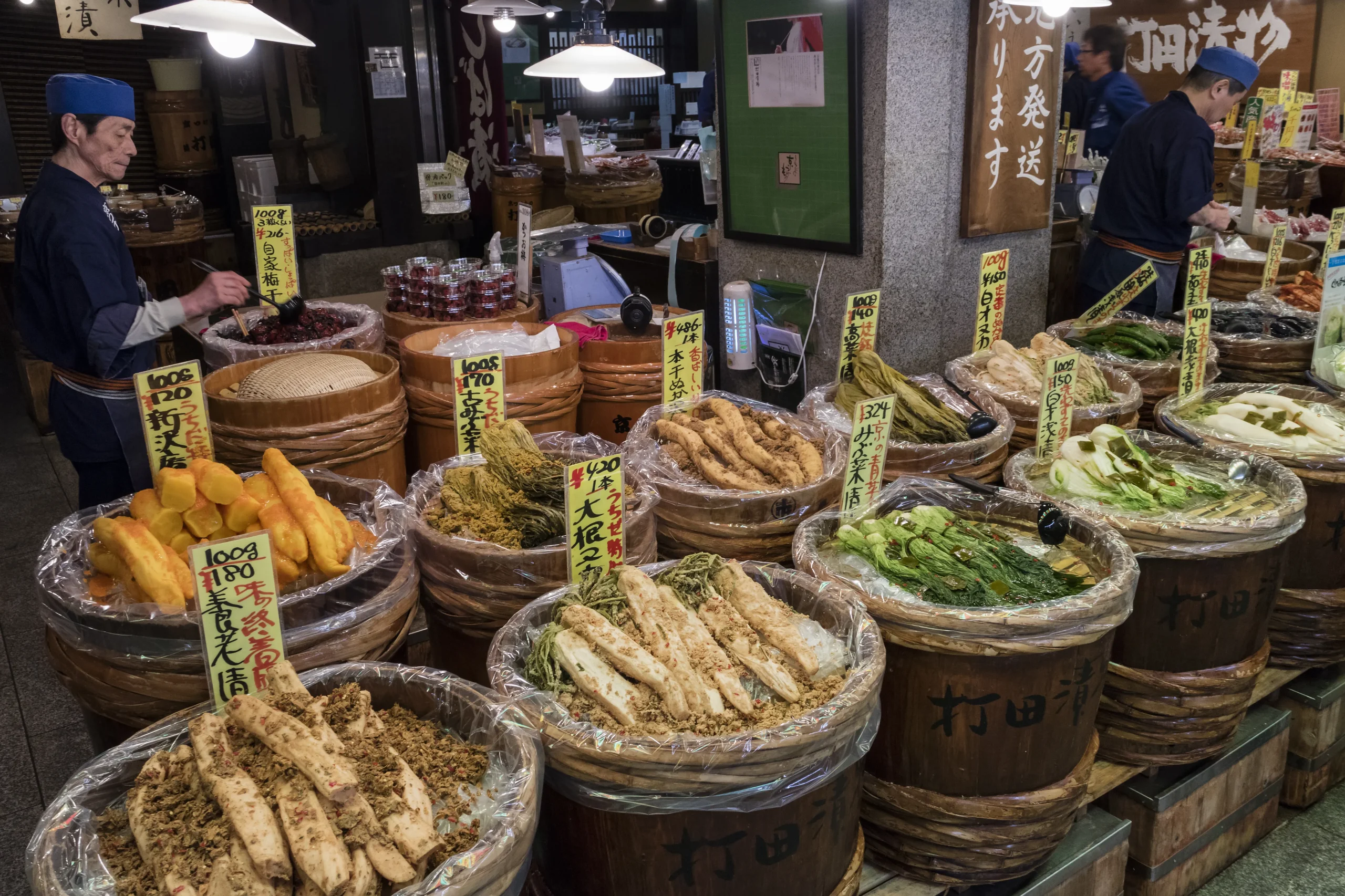 Traditional Japanese pickles (tsukemono) displayed in barrels at a market