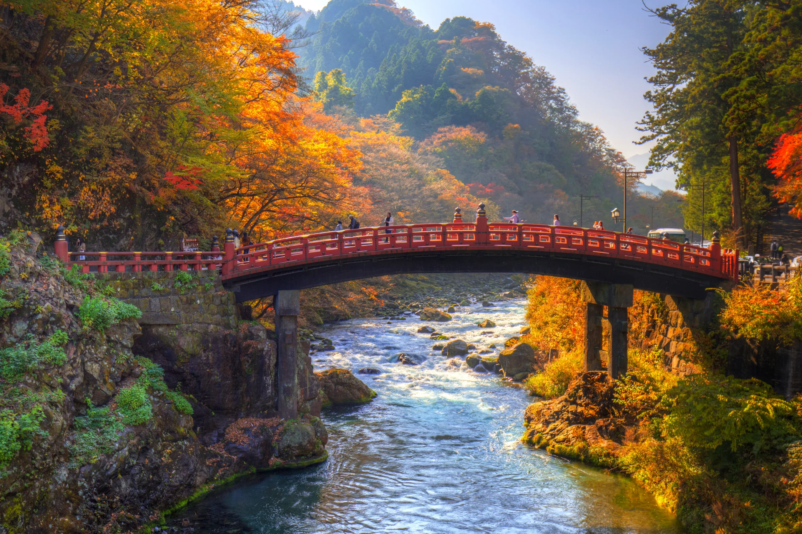 Red Shinkyo Bridge surrounded by colorful autumn foliage in Nikko, Tochigi, Japan