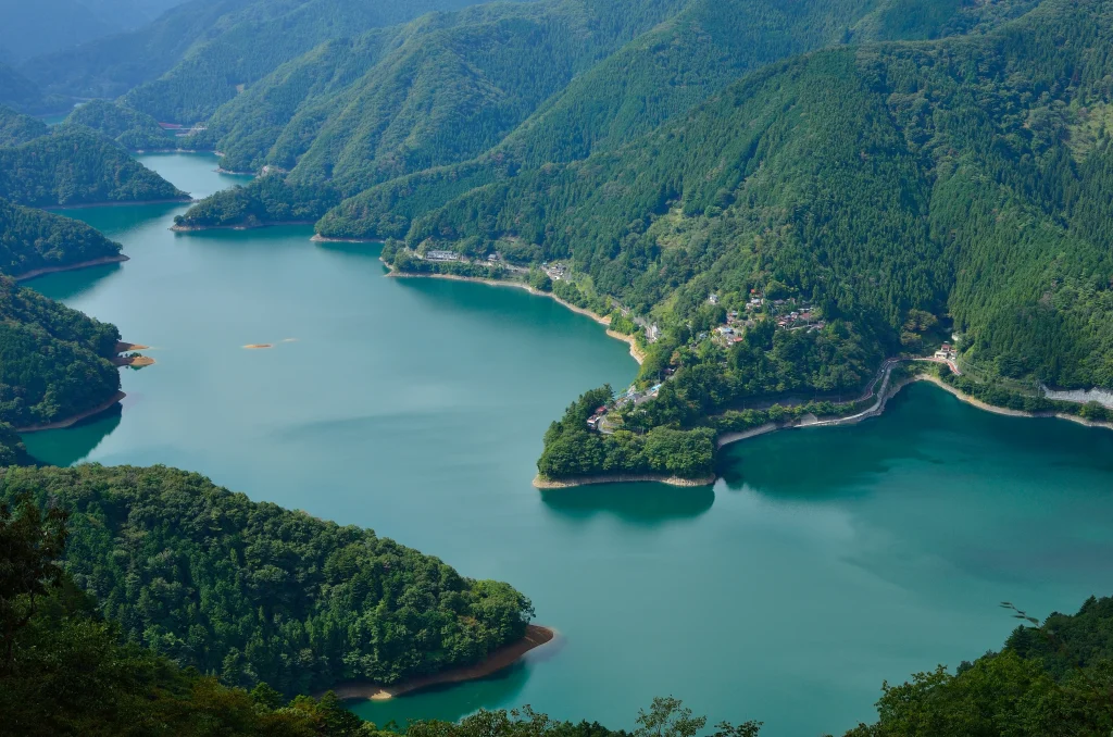 Panoramic view of Okutama Lake surrounded by forested mountains in western Tokyo, Japan