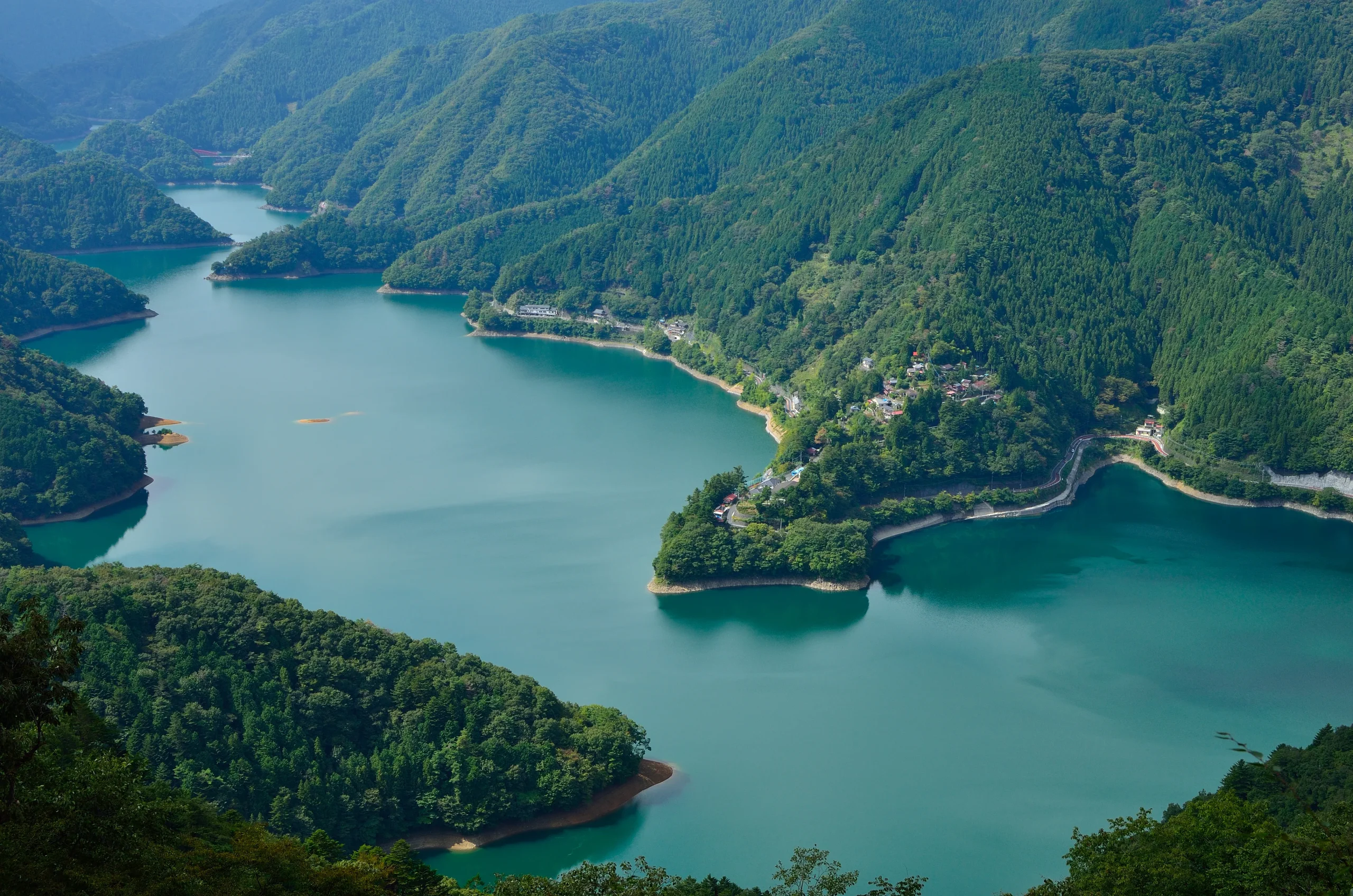 Panoramic view of Okutama Lake surrounded by forested mountains in western Tokyo, Japan
