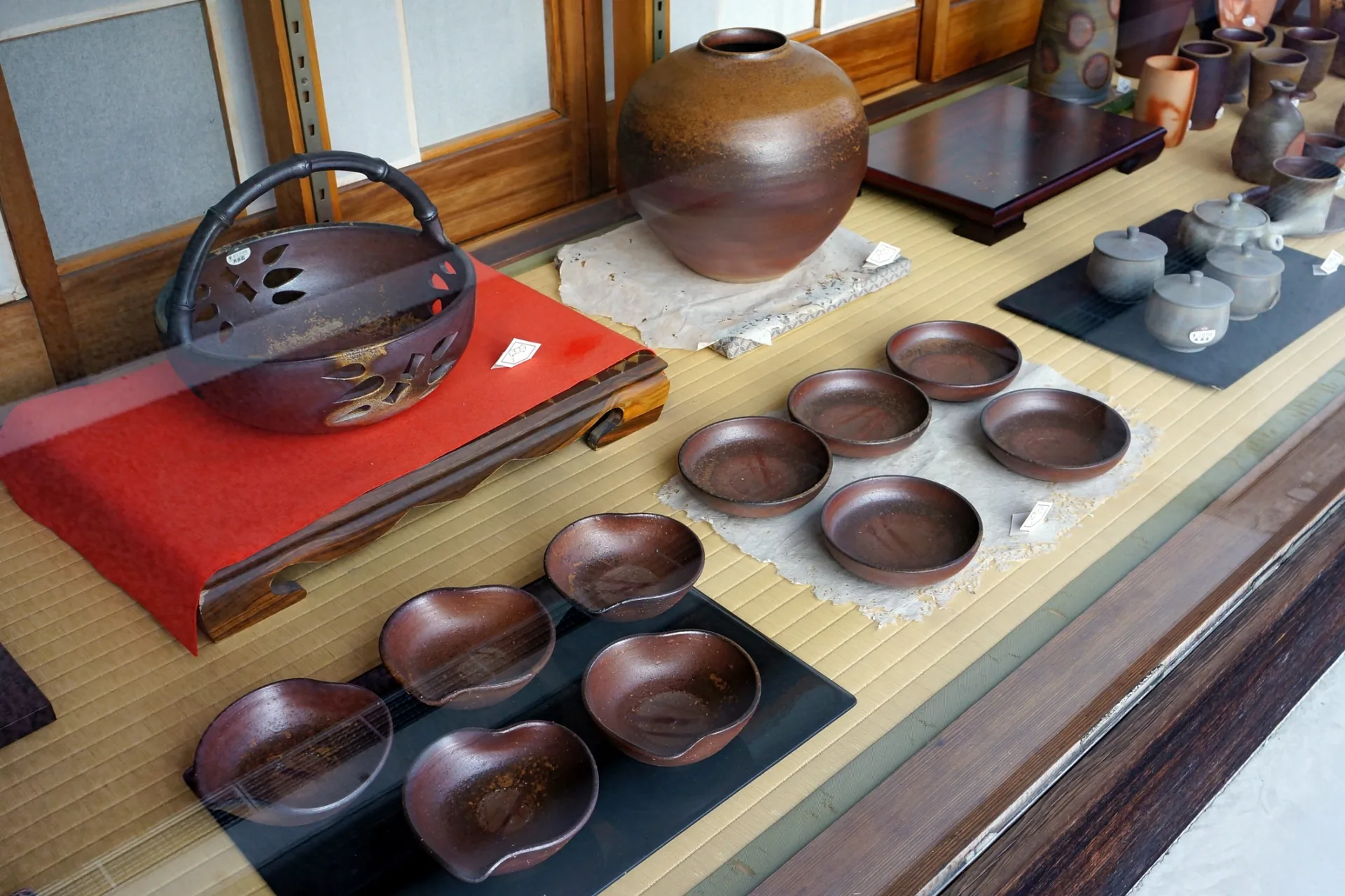 Bizen ware bowls, plates and vessels displayed on tatami in Imbe, Okayama