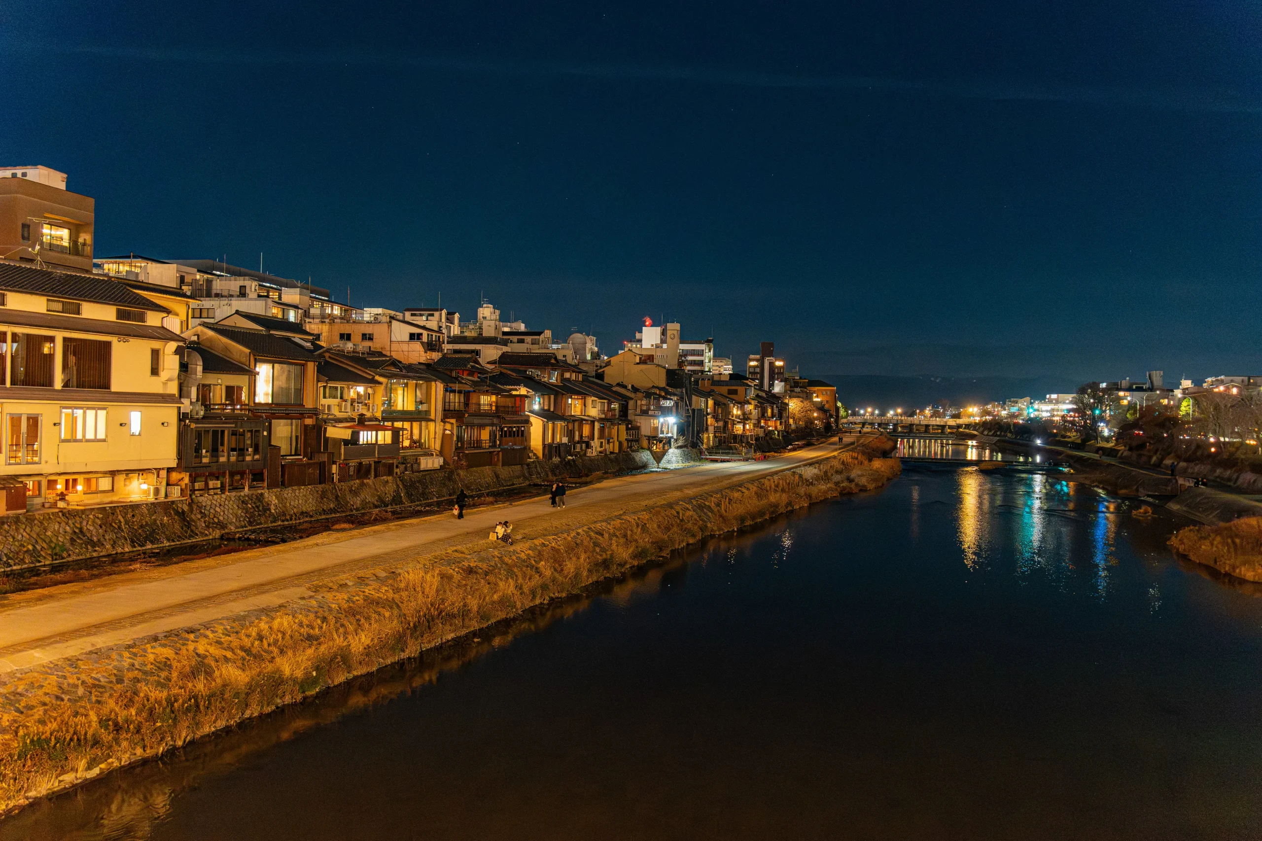 Night view of the Kamo River and surrounding streets near Shijō Kawaramachi and Gion in Kyoto.